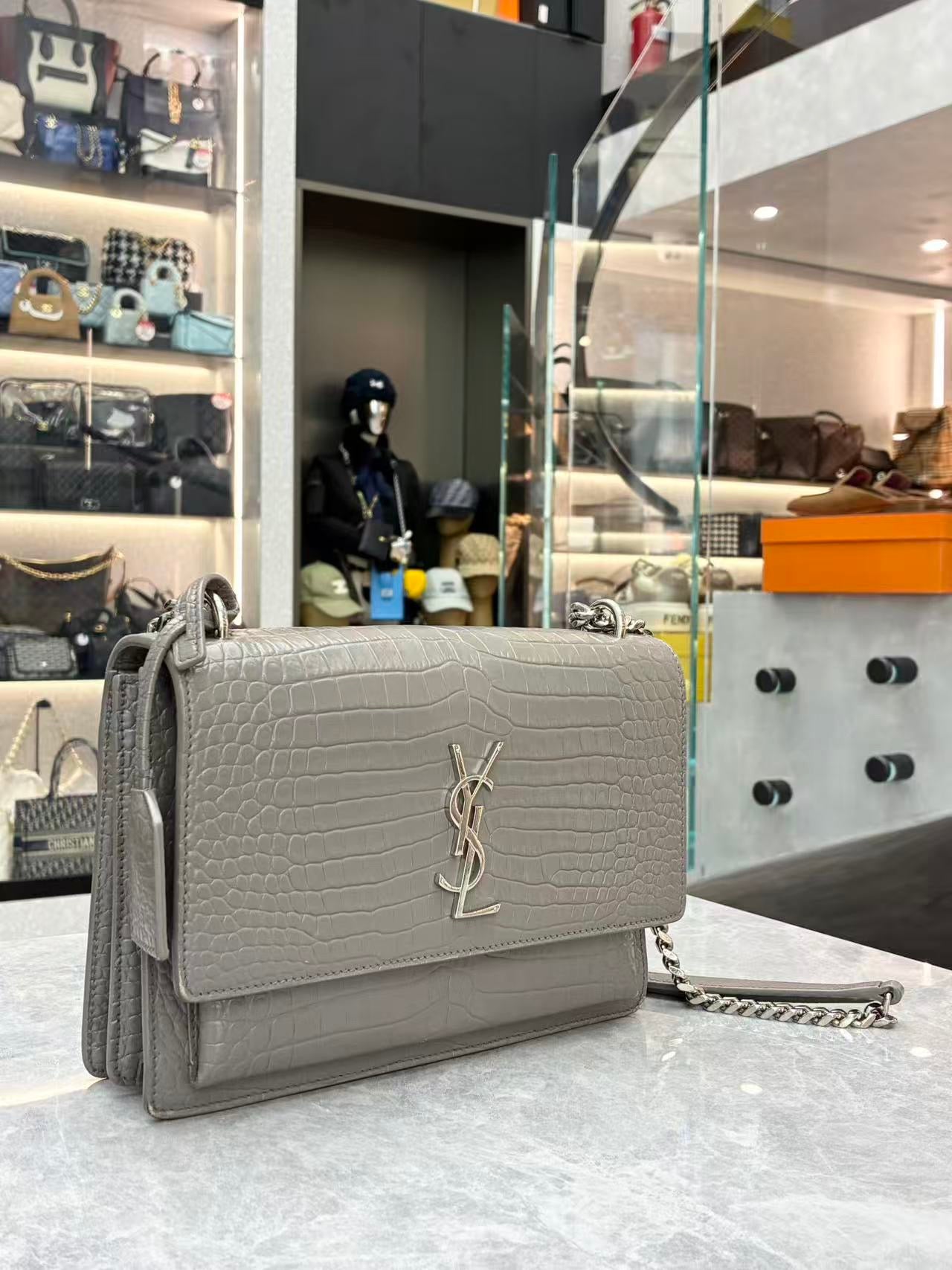Saint Laurent Sunset Medium shoulder bag made from croc-embossed grey calfskin leather with silver hardware.