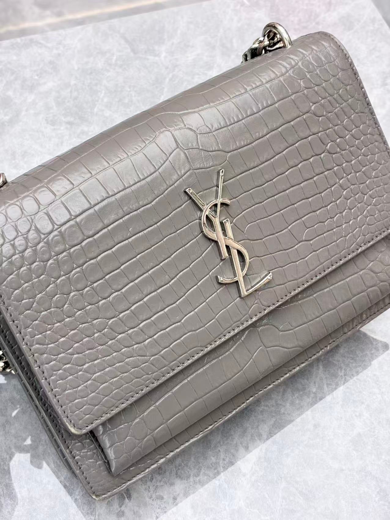 Saint Laurent Sunset Medium shoulder bag made from croc-embossed grey calfskin leather with silver hardware.