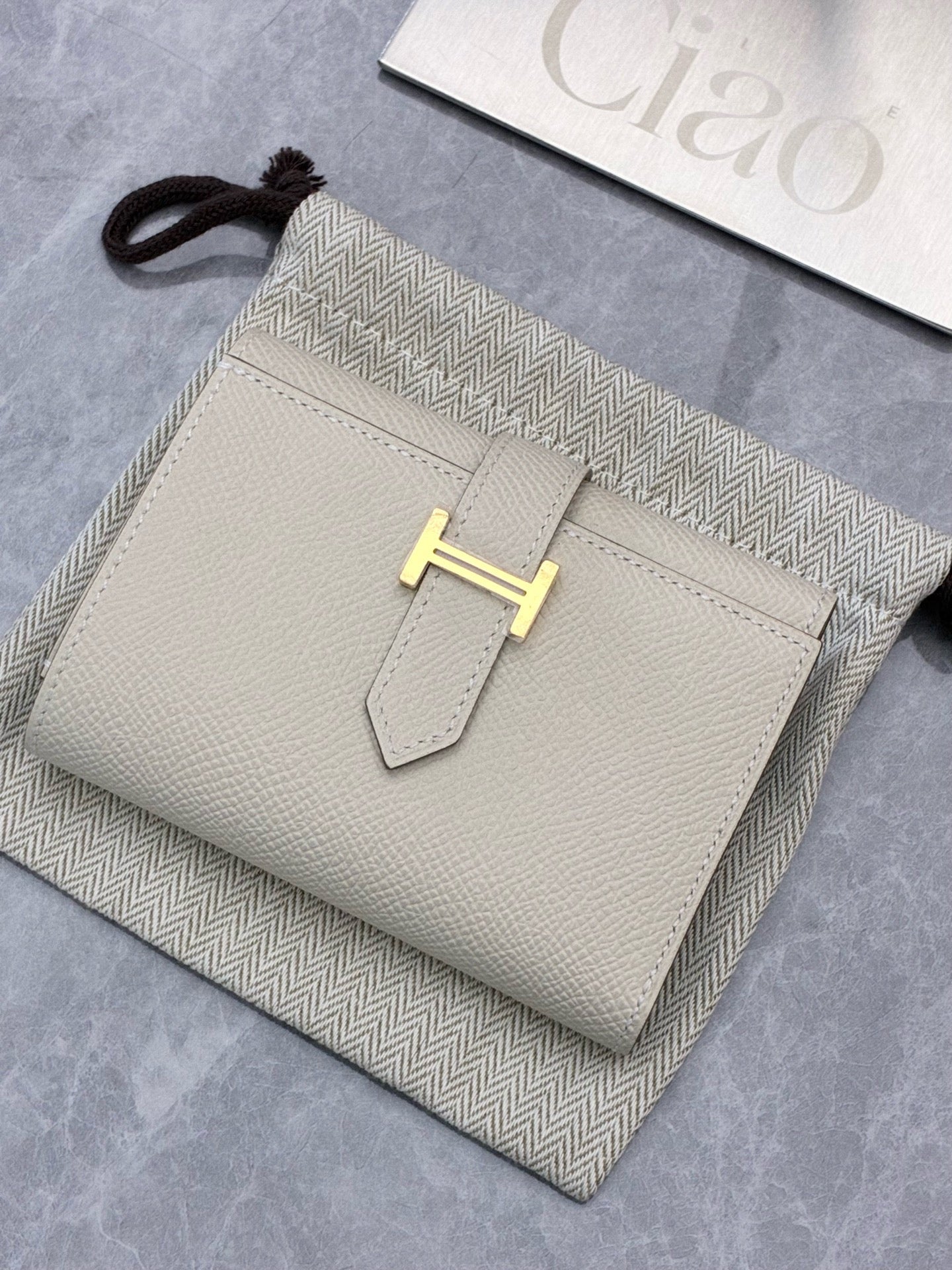 Hermès Bearn Compact wallet in a light beige shade, likely Craie or Gris Asphalte, featuring gold hardware