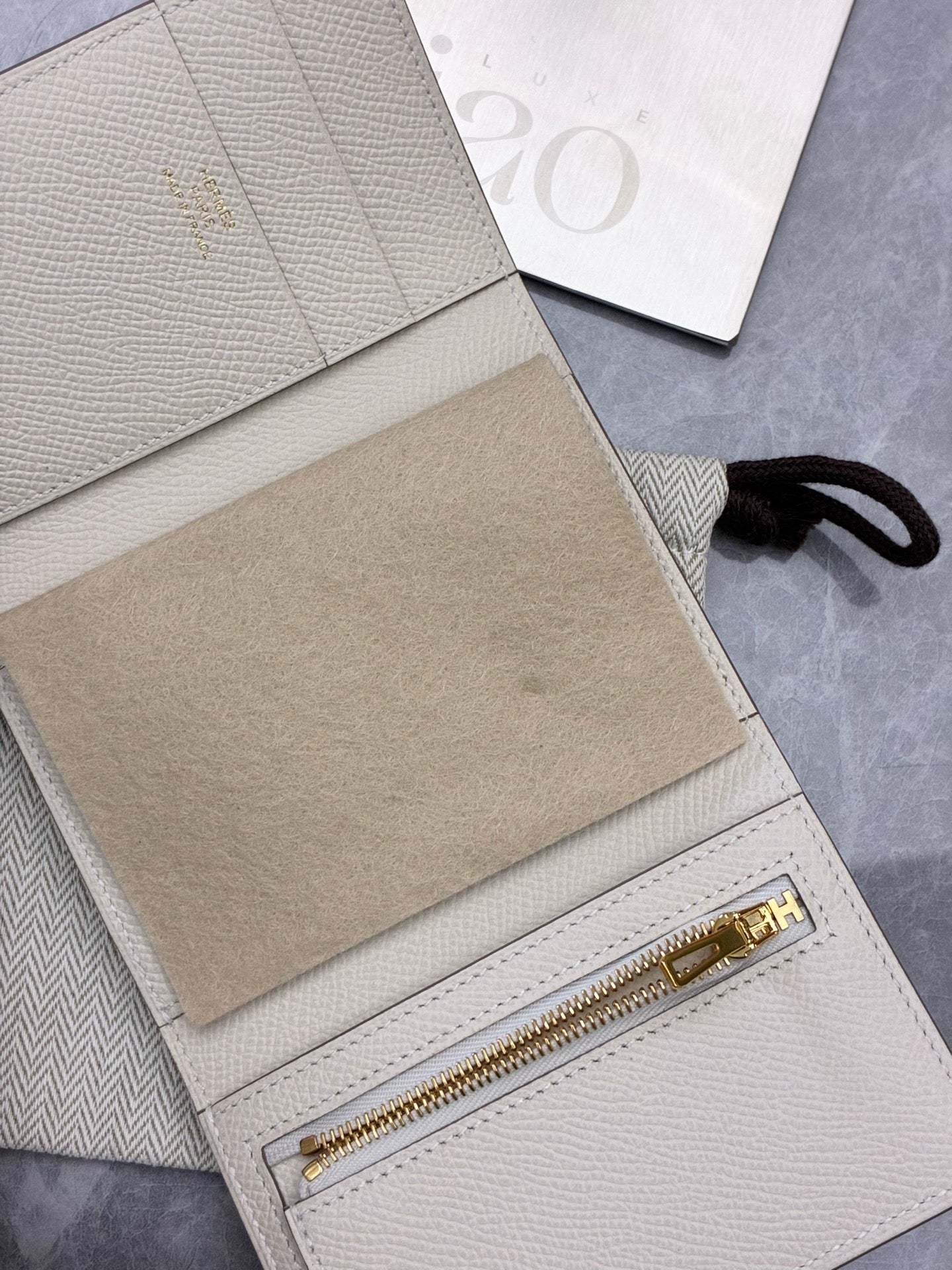 Hermès Bearn Compact wallet in a light beige shade, likely Craie or Gris Asphalte, featuring gold hardware