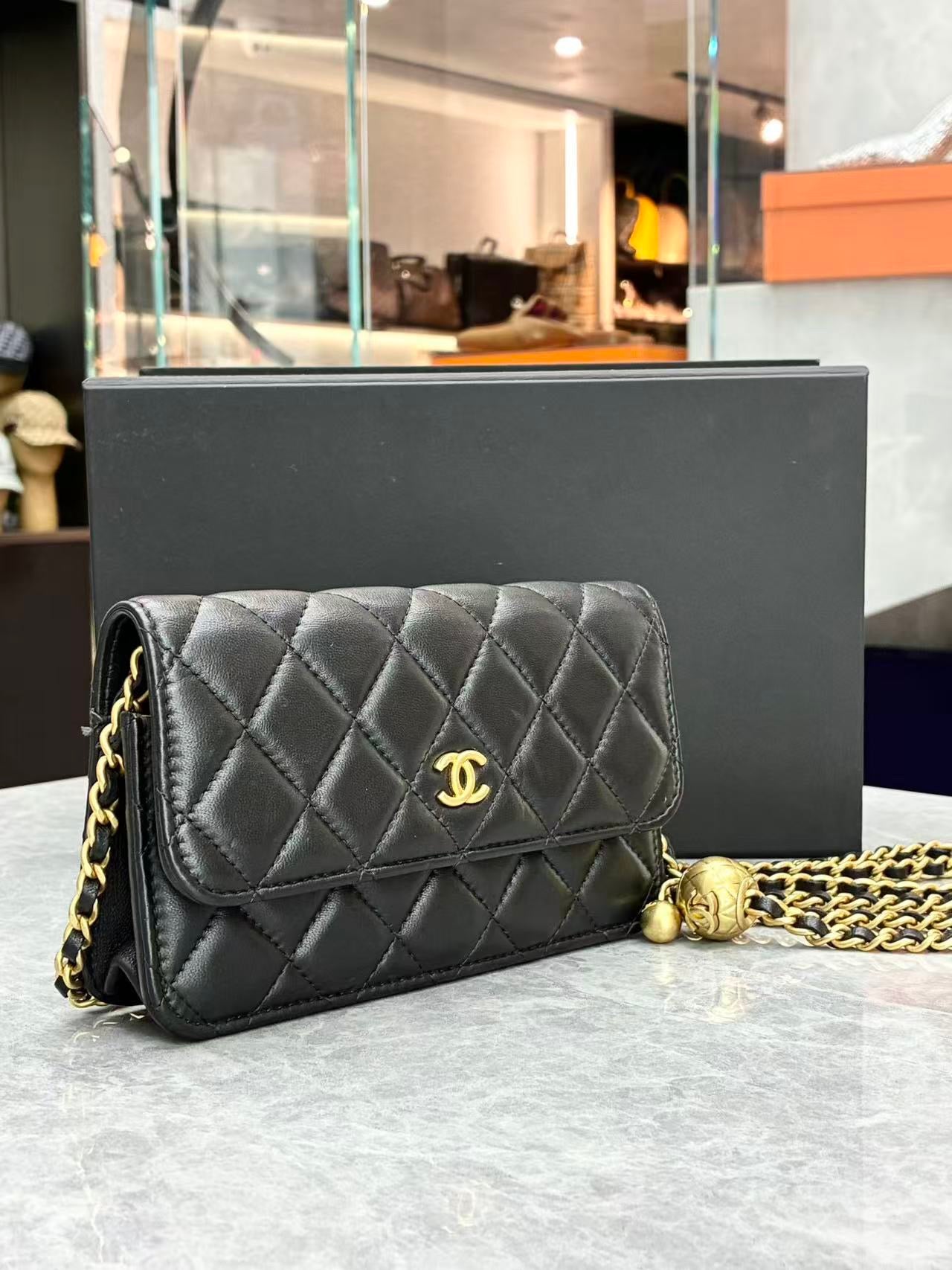 Chanel quilted lambskin wallet on chain, specifically the "Pearl Crush" variant featuring a distinctive adjustable ball charm on the chain strap