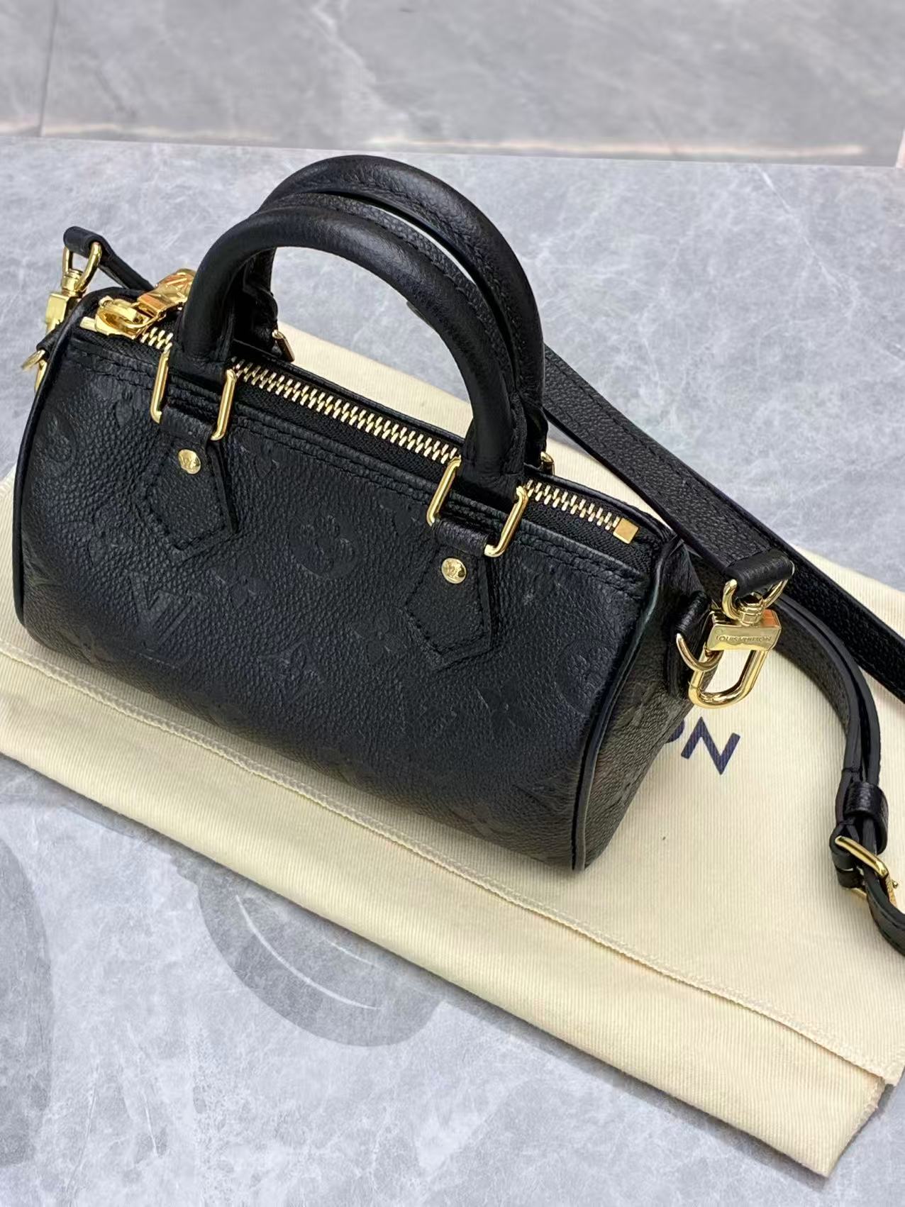 Louis Vuitton Nano Speedy bag featuring black embossed Monogram Empreinte leather and gold-tone hardware