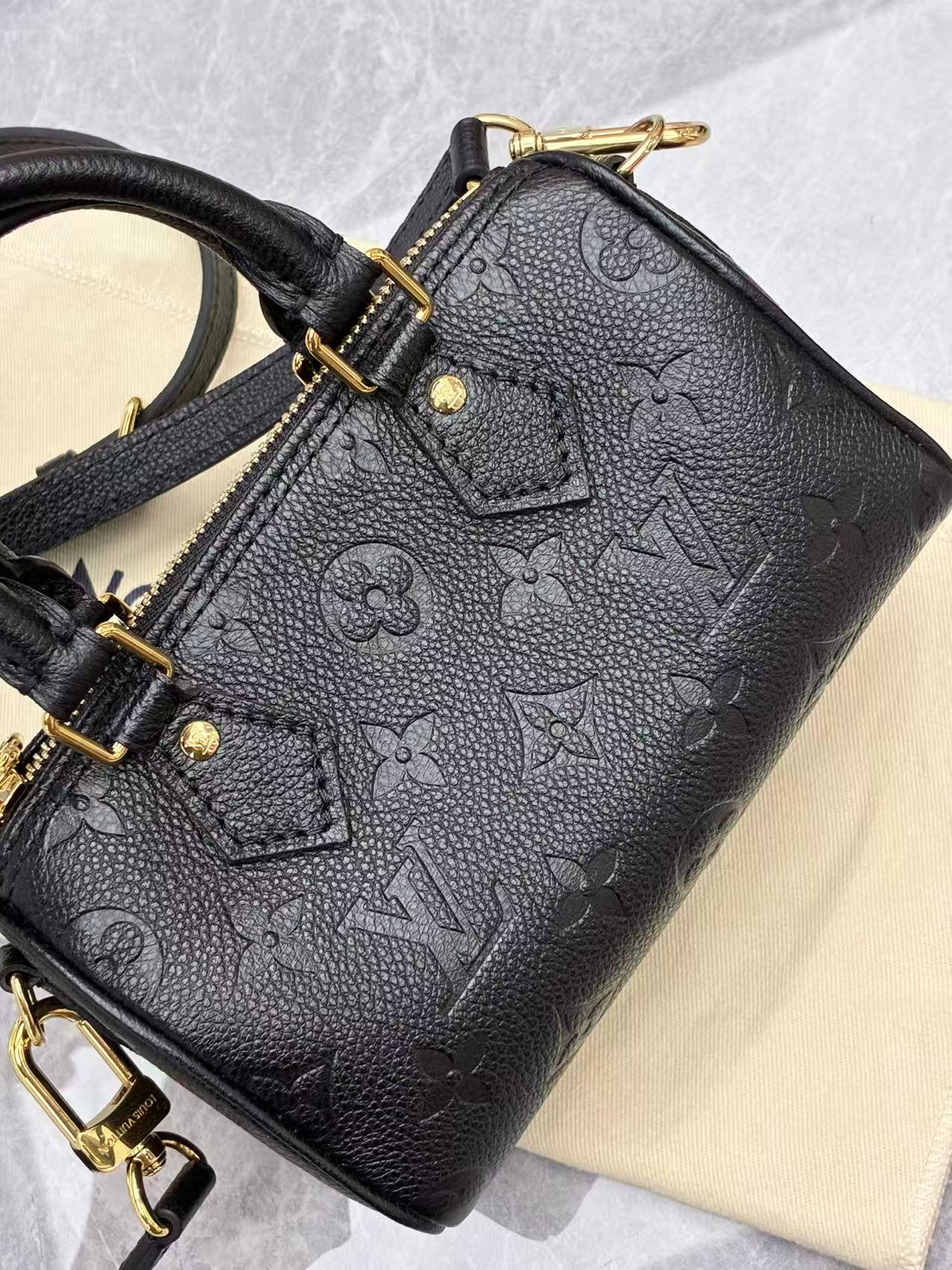 Louis Vuitton Nano Speedy bag featuring black embossed Monogram Empreinte leather and gold-tone hardware