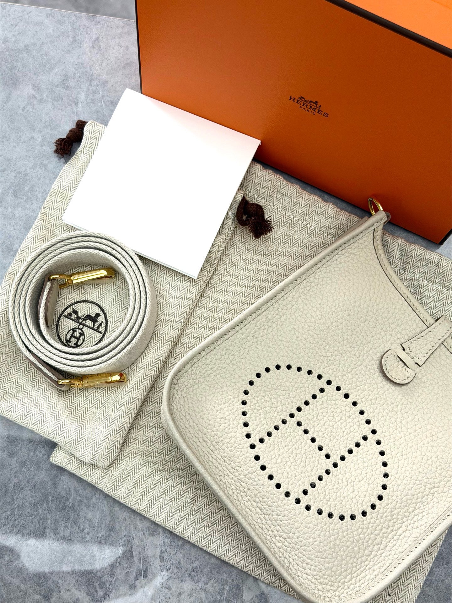 Hermès Evelyne 16 TPM bag is crafted from light-colored Clemence leather with silver-tone hardware