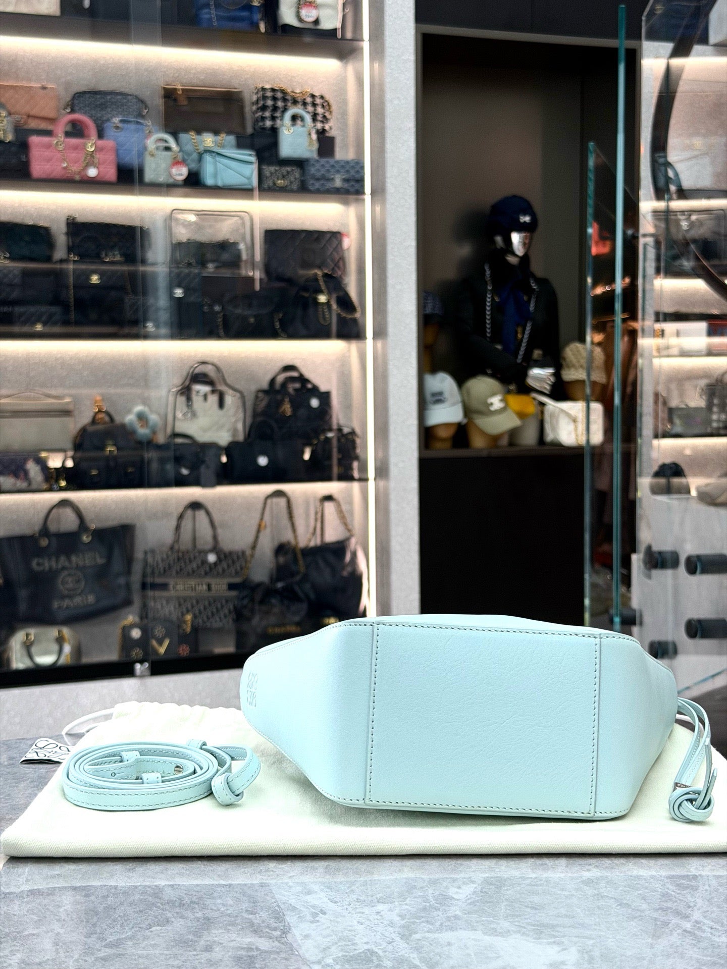 Loewe Mini Hammock Hobo bag features a distinct curved shape crafted from light blue calfskin leather