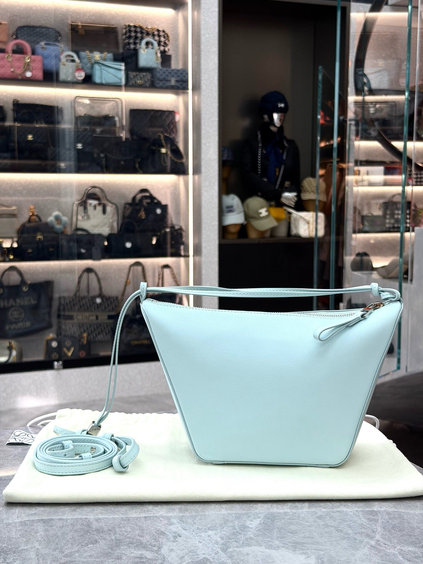 Loewe Mini Hammock Hobo bag features a distinct curved shape crafted from light blue calfskin leather
