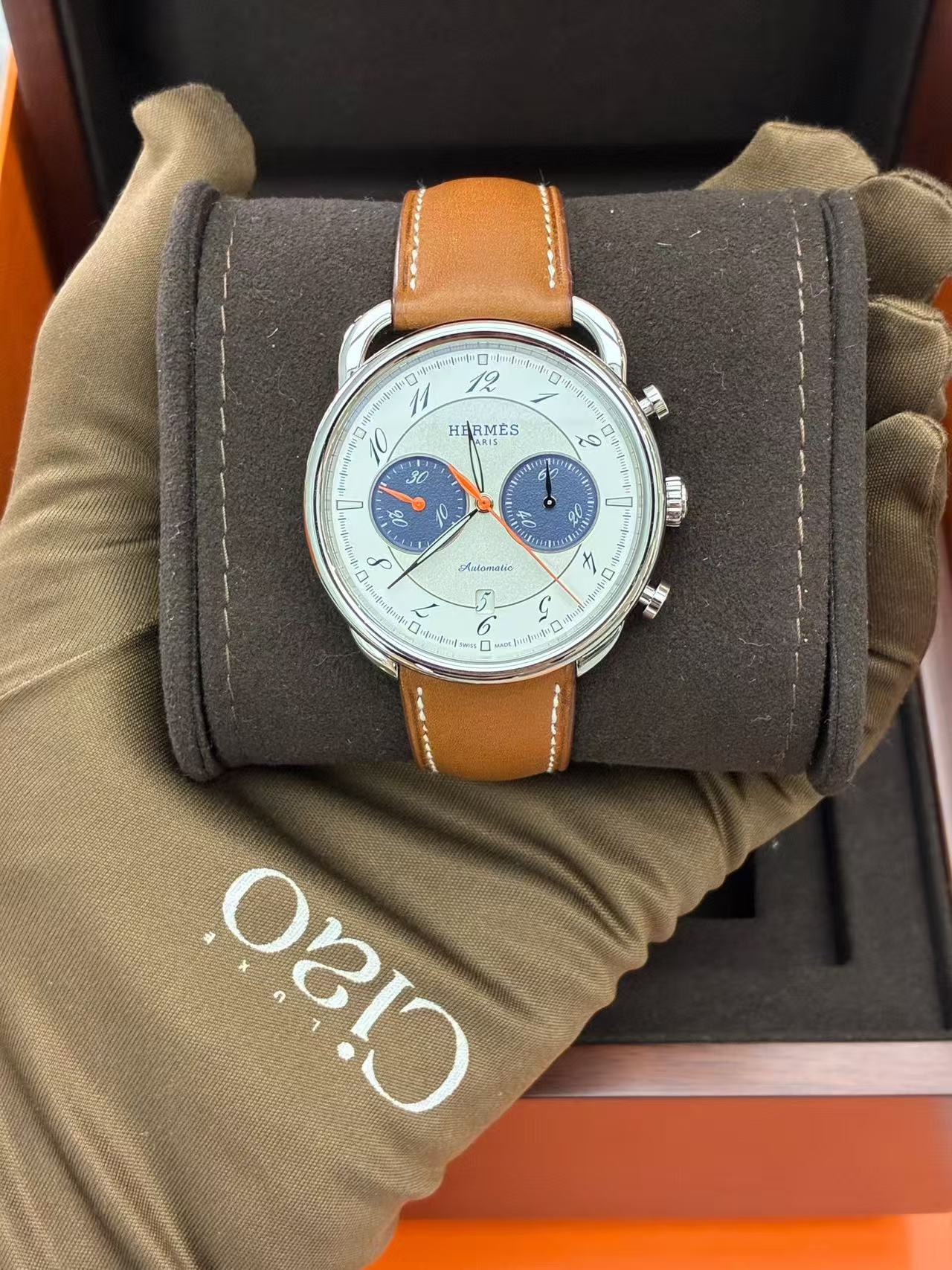 Hermès Arceau Chronograph 42mm watch featuring a white silvered dial, blue counters, and a brown leather strap