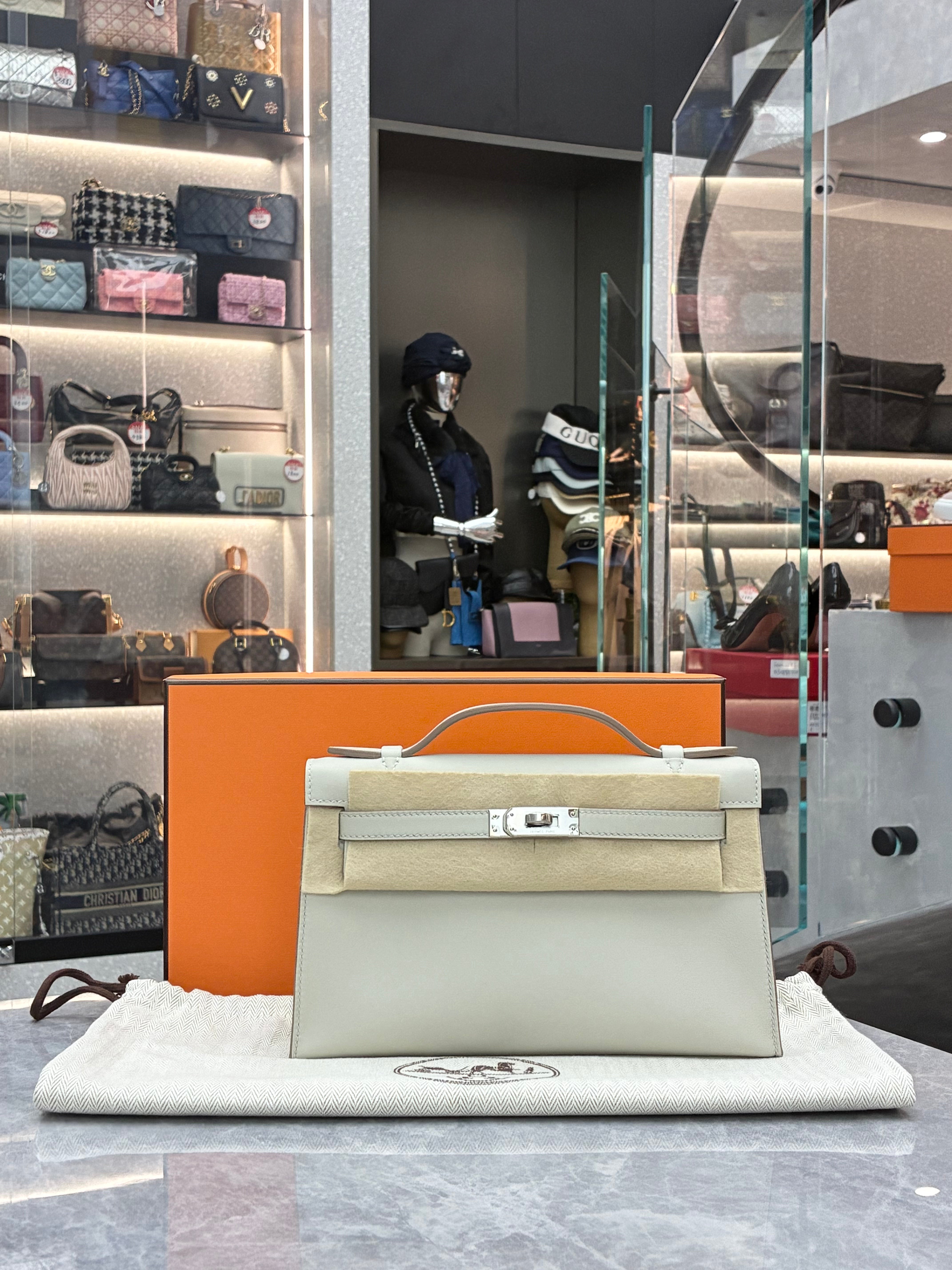 Hermès Kelly Pochette, often crafted in leathers like Swift in colors Gris Perle, paired with palladium hardware