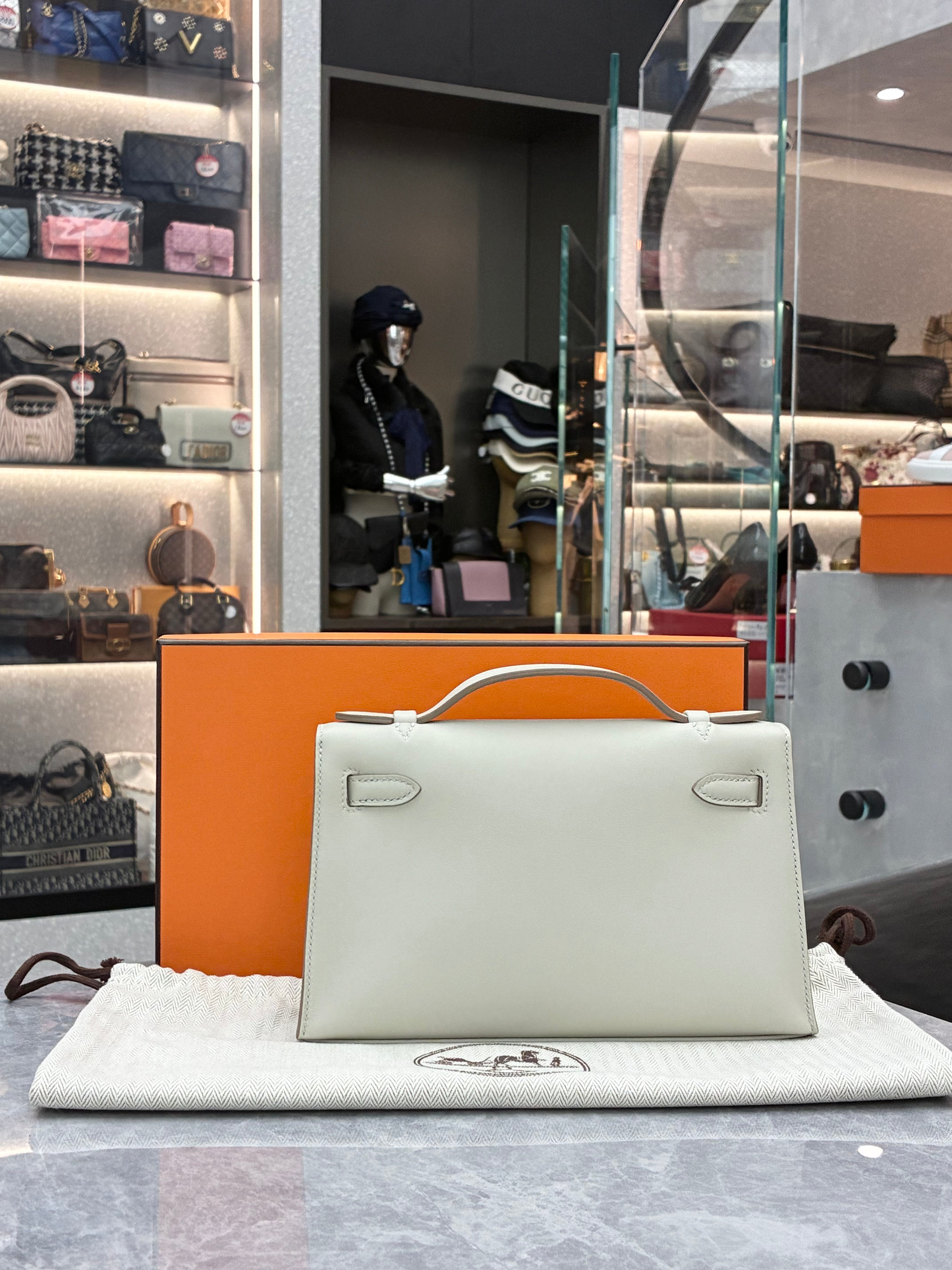 Hermès Kelly Pochette, often crafted in leathers like Swift in colors Gris Perle, paired with palladium hardware