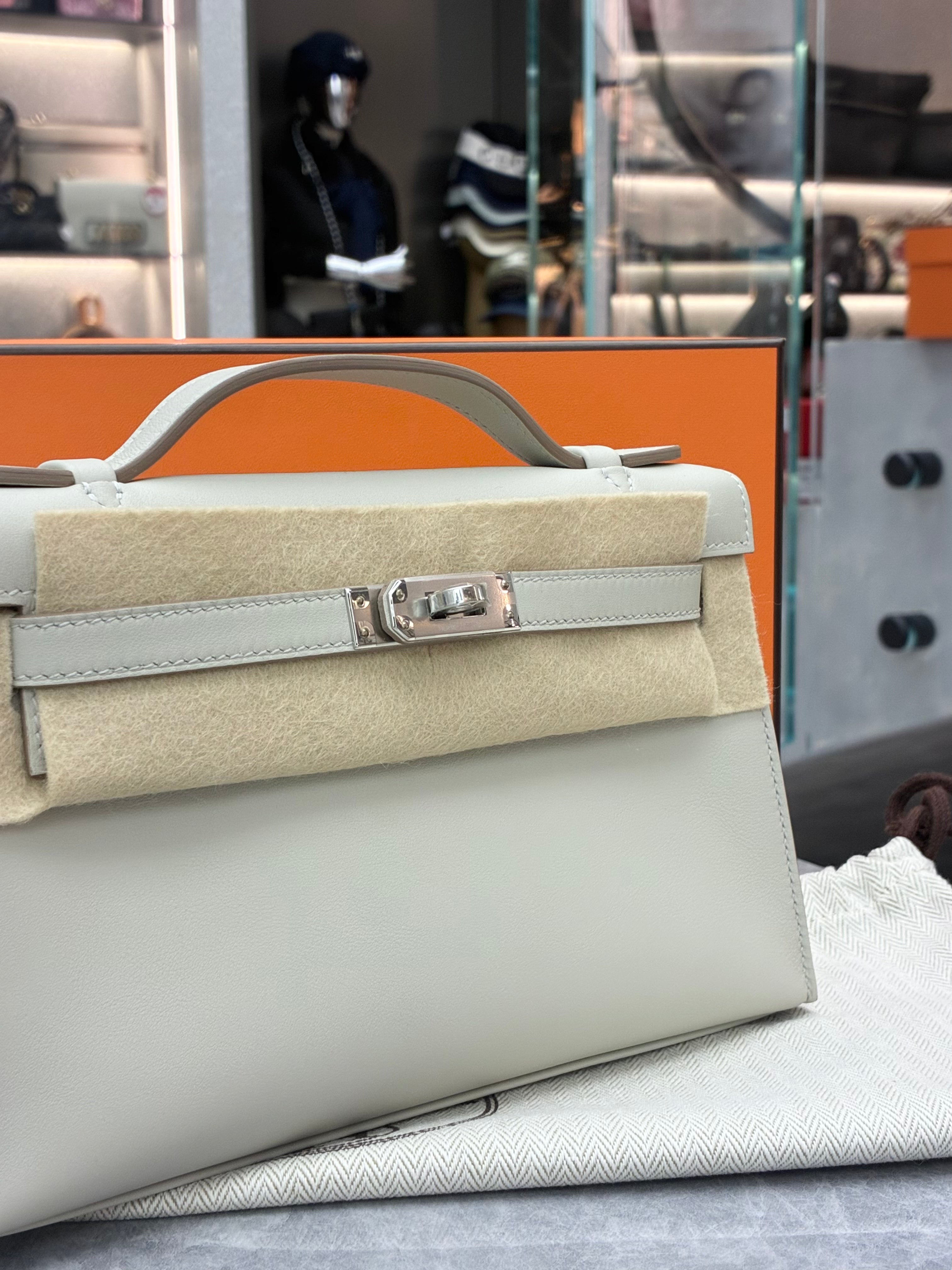 Hermès Kelly Pochette, often crafted in leathers like Swift in colors Gris Perle, paired with palladium hardware