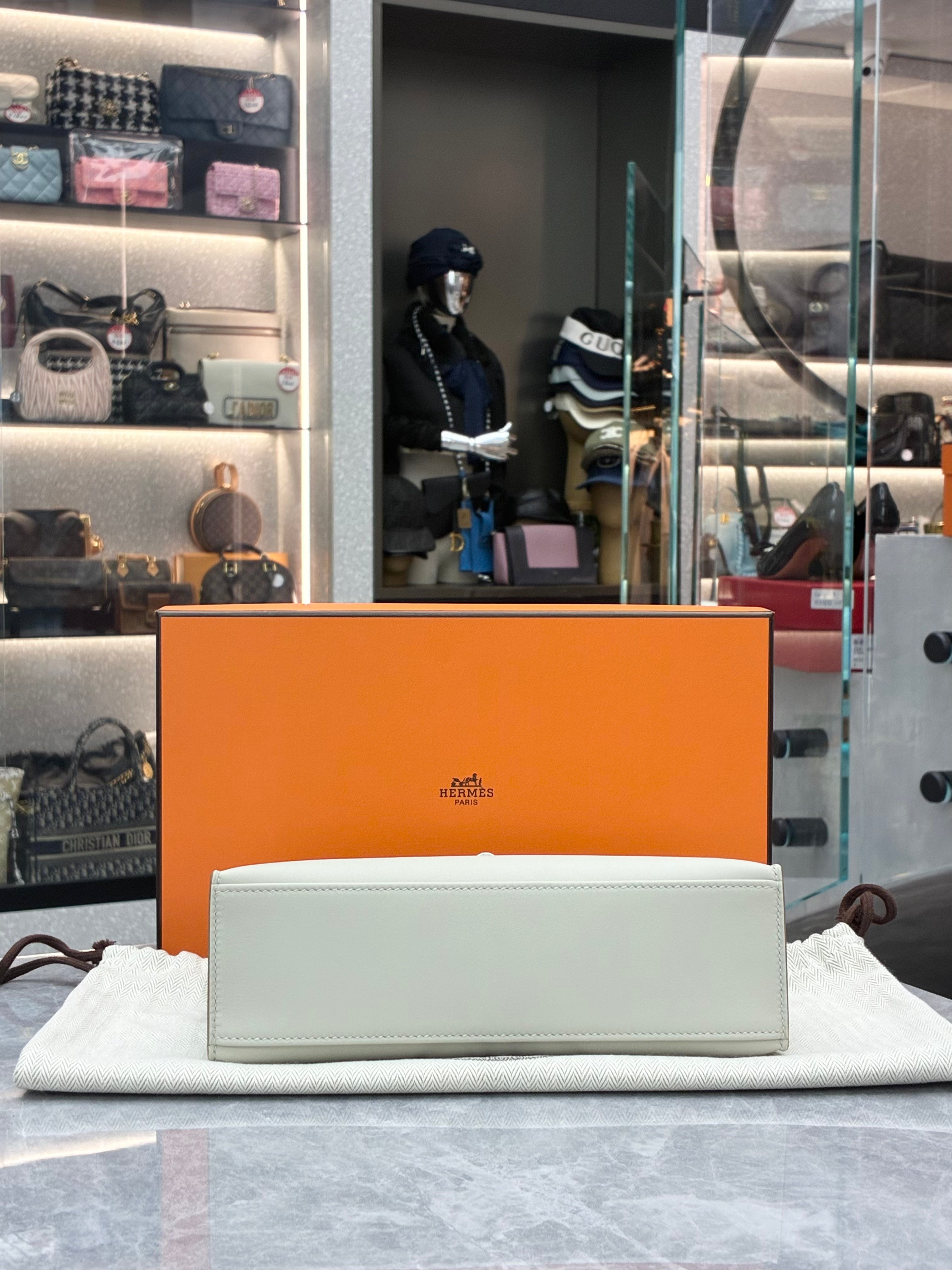 Hermès Kelly Pochette, often crafted in leathers like Swift in colors Gris Perle, paired with palladium hardware