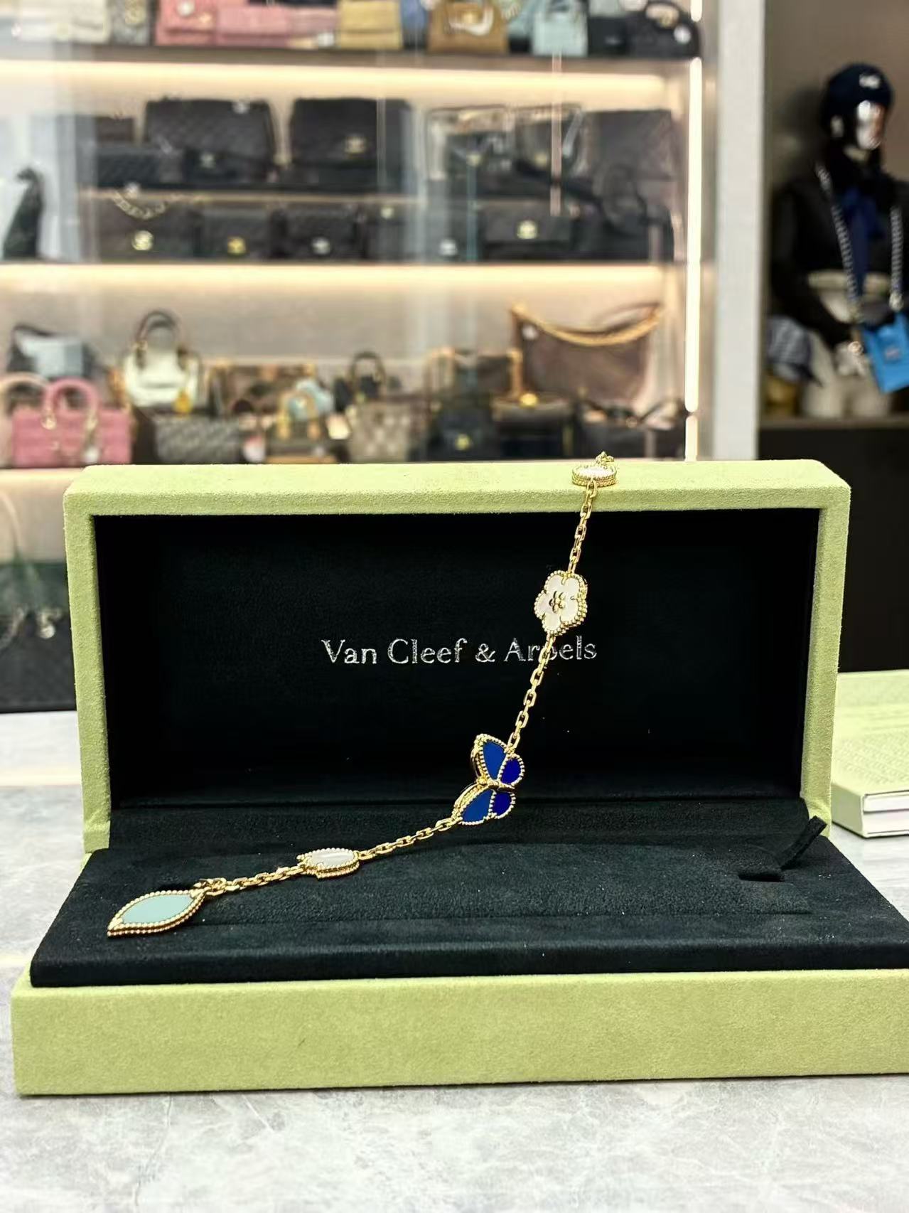 Van Cleef & Arpels Lucky Spring Butterfly bracelet in 18K yellow gold, featuring motifs made from white mother-of-pearl, onyx, lapis lazuli, and agate