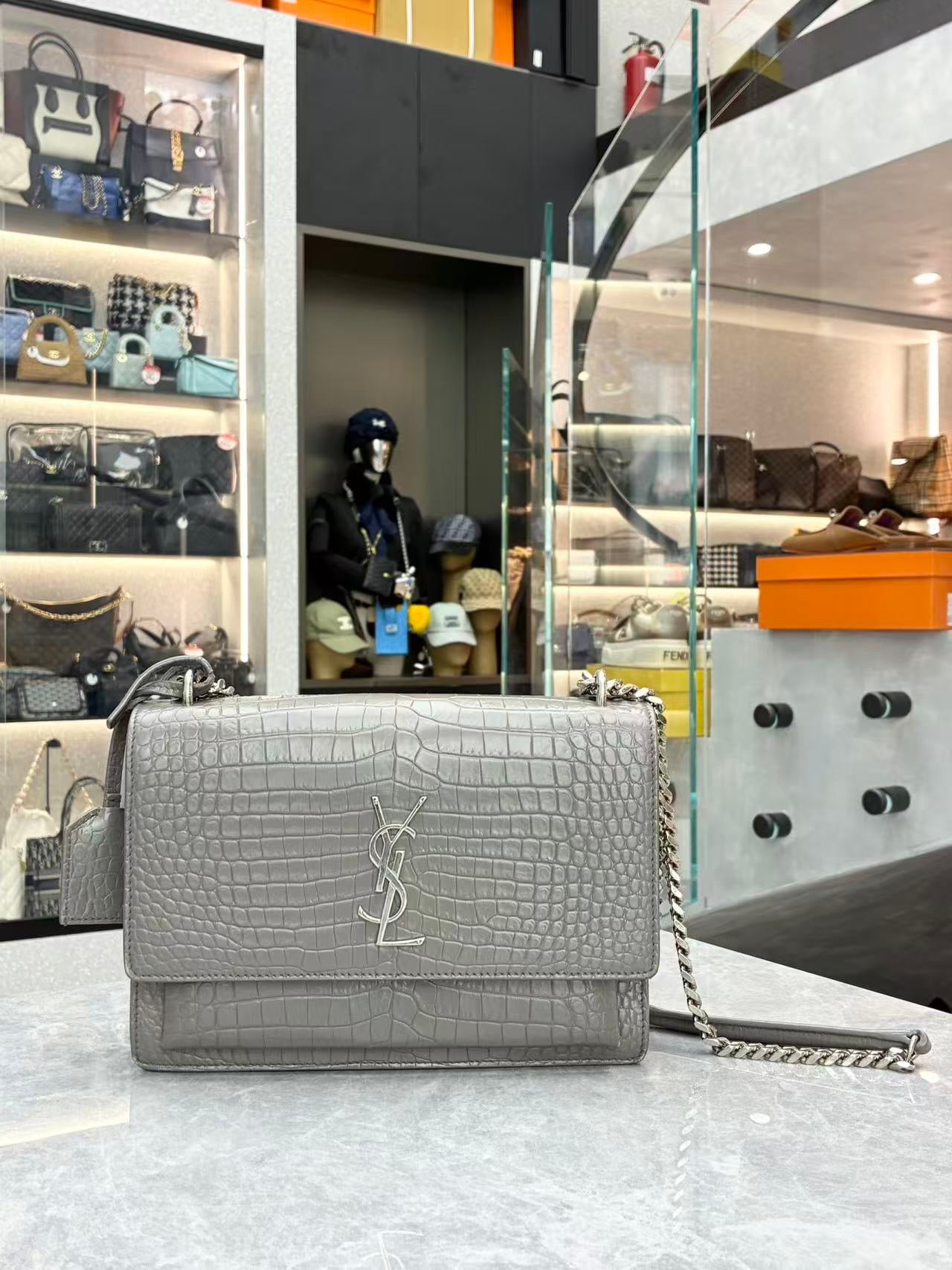 Saint Laurent Sunset Medium shoulder bag made from croc-embossed grey calfskin leather with silver hardware.