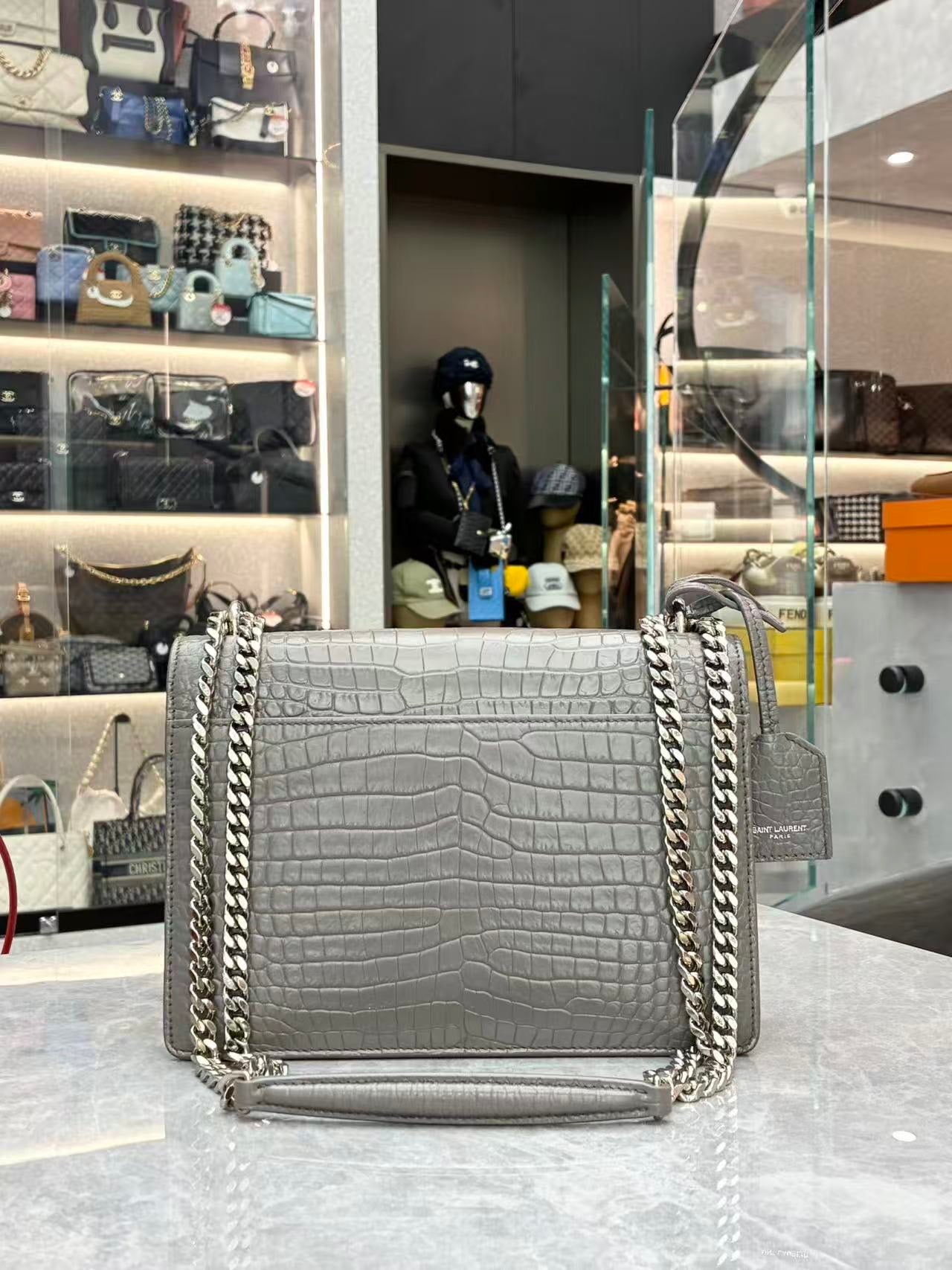 Saint Laurent Sunset Medium shoulder bag made from croc-embossed grey calfskin leather with silver hardware.