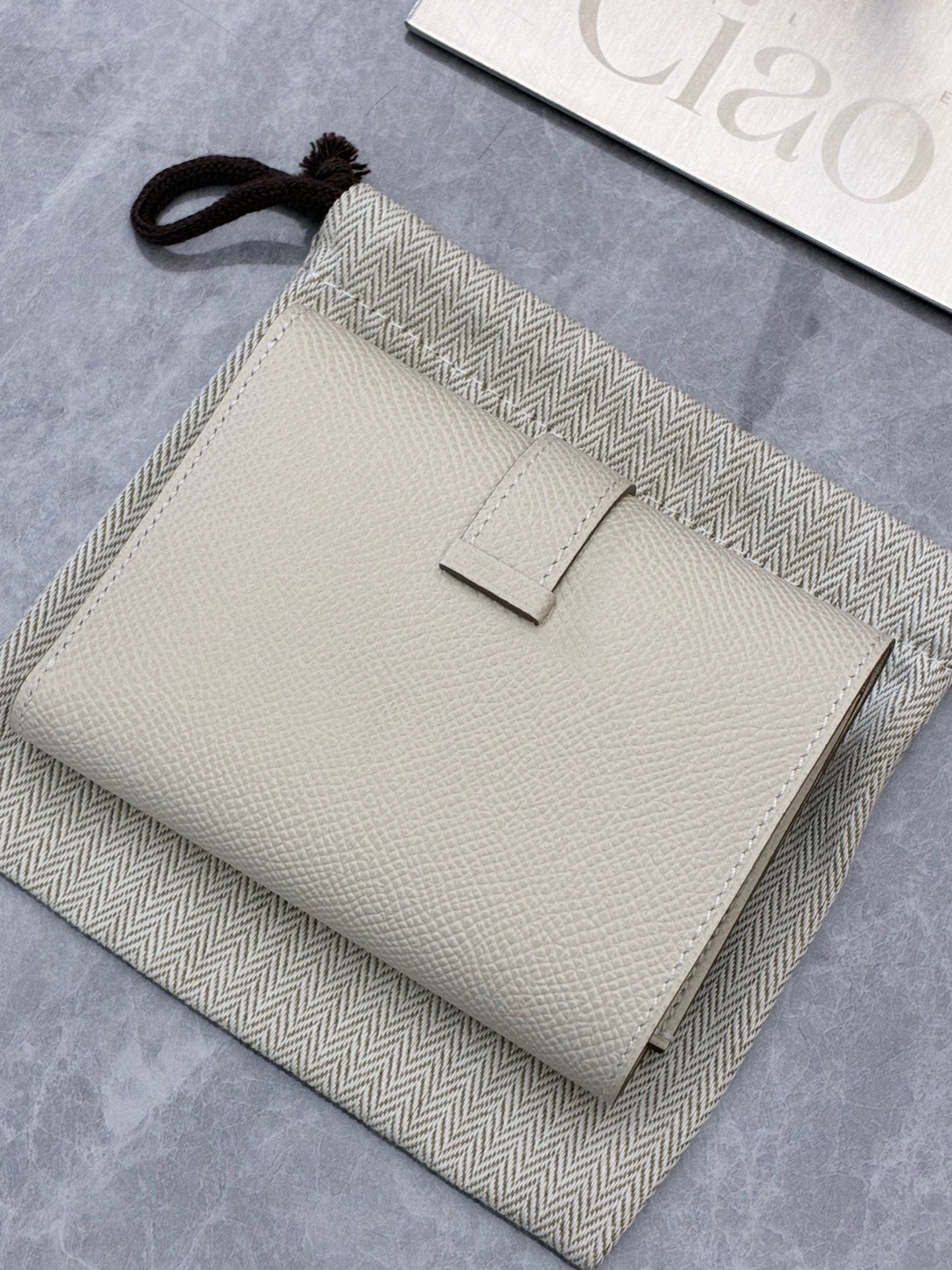 Hermès Bearn Compact wallet in a light beige shade, likely Craie or Gris Asphalte, featuring gold hardware