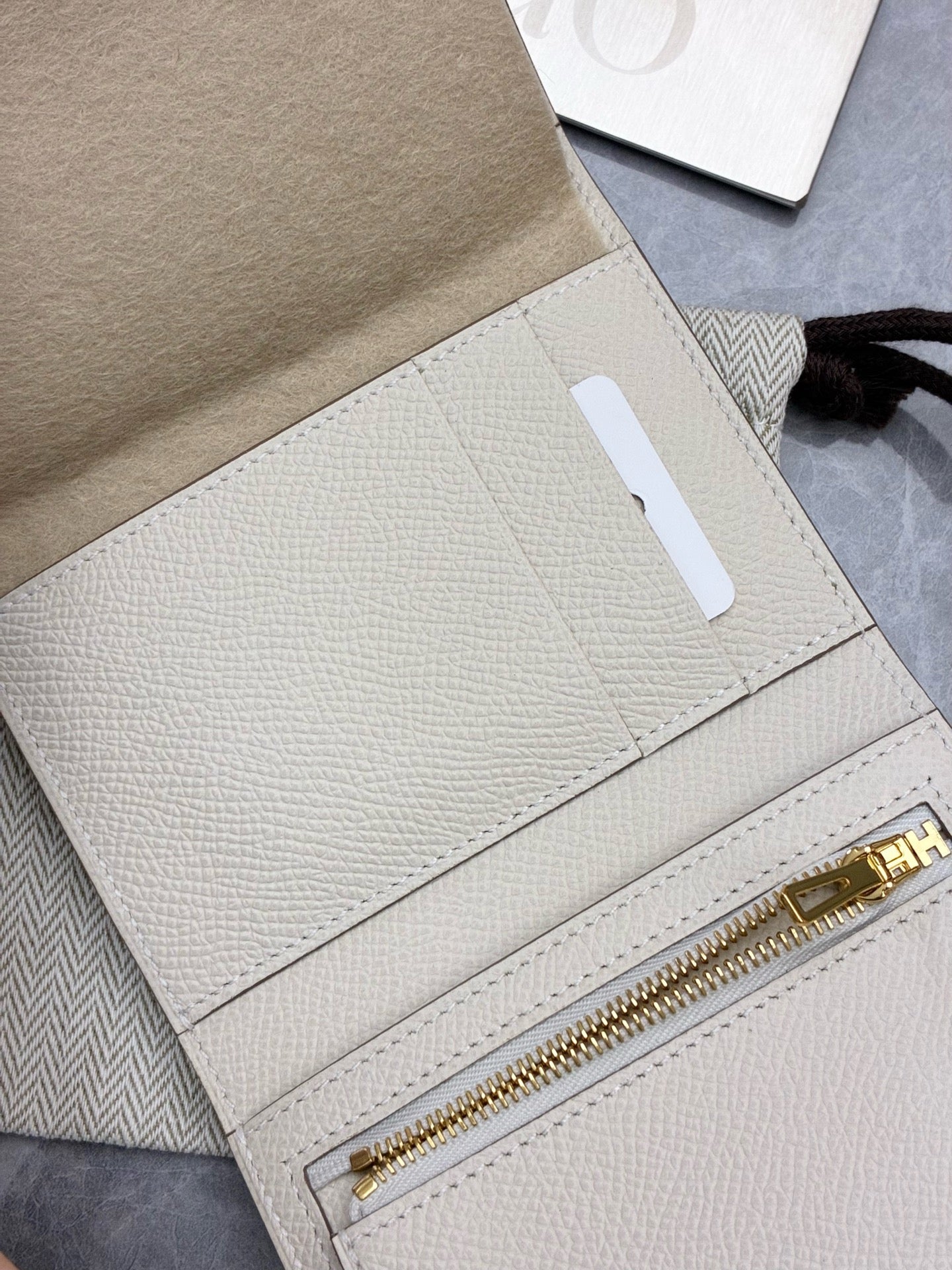 Hermès Bearn Compact wallet in a light beige shade, likely Craie or Gris Asphalte, featuring gold hardware