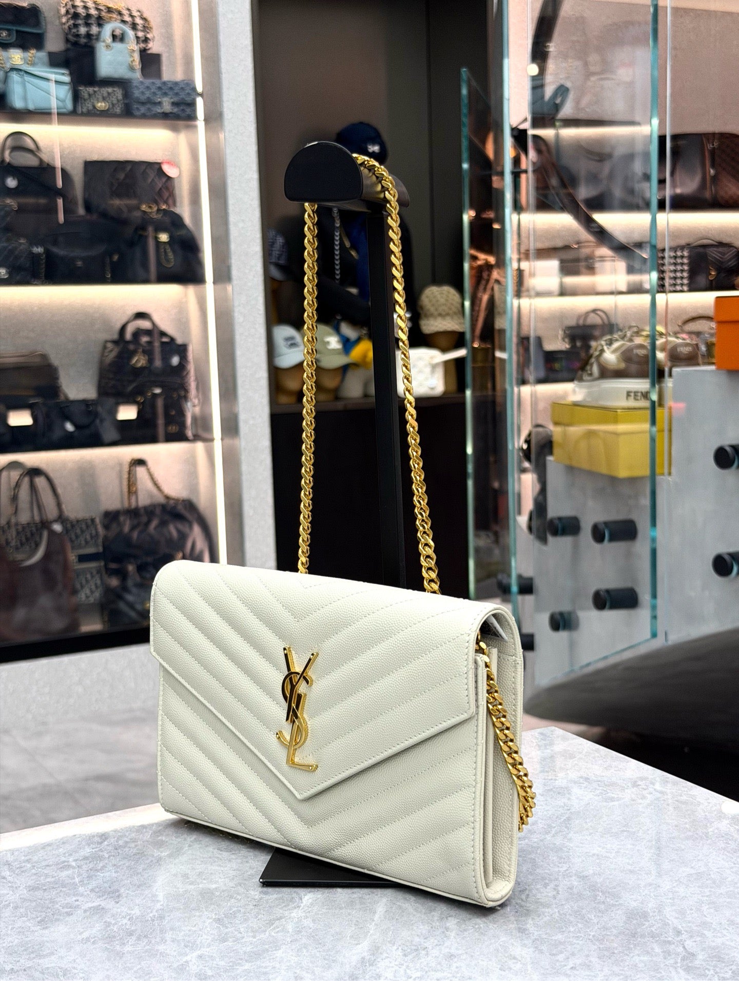 Saint Laurent Cassandre Envelope Chain Wallet crafted from white chevron-quilted leather