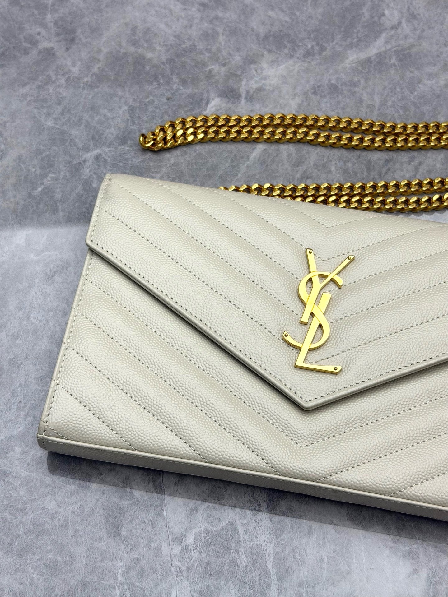 Saint Laurent Cassandre Envelope Chain Wallet crafted from white chevron-quilted leather
