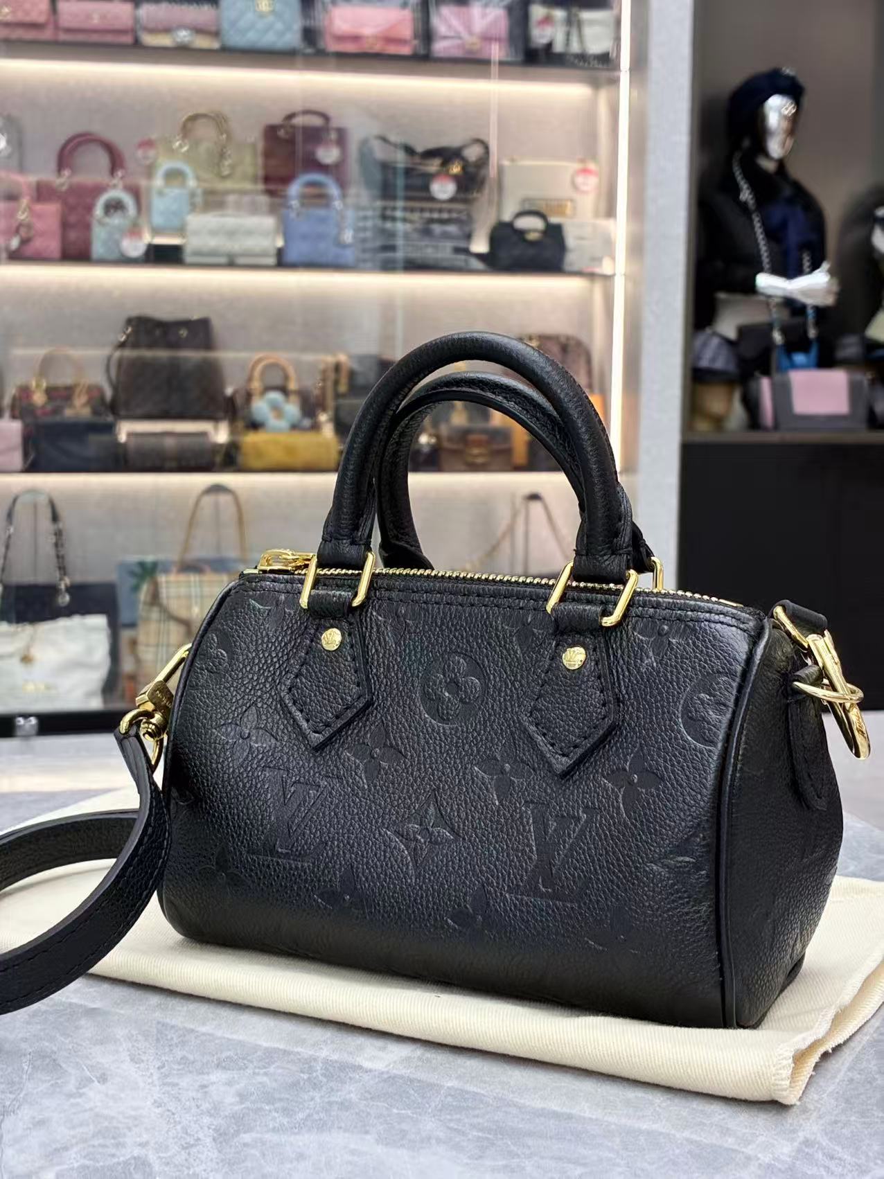 Louis Vuitton Nano Speedy bag featuring black embossed Monogram Empreinte leather and gold-tone hardware