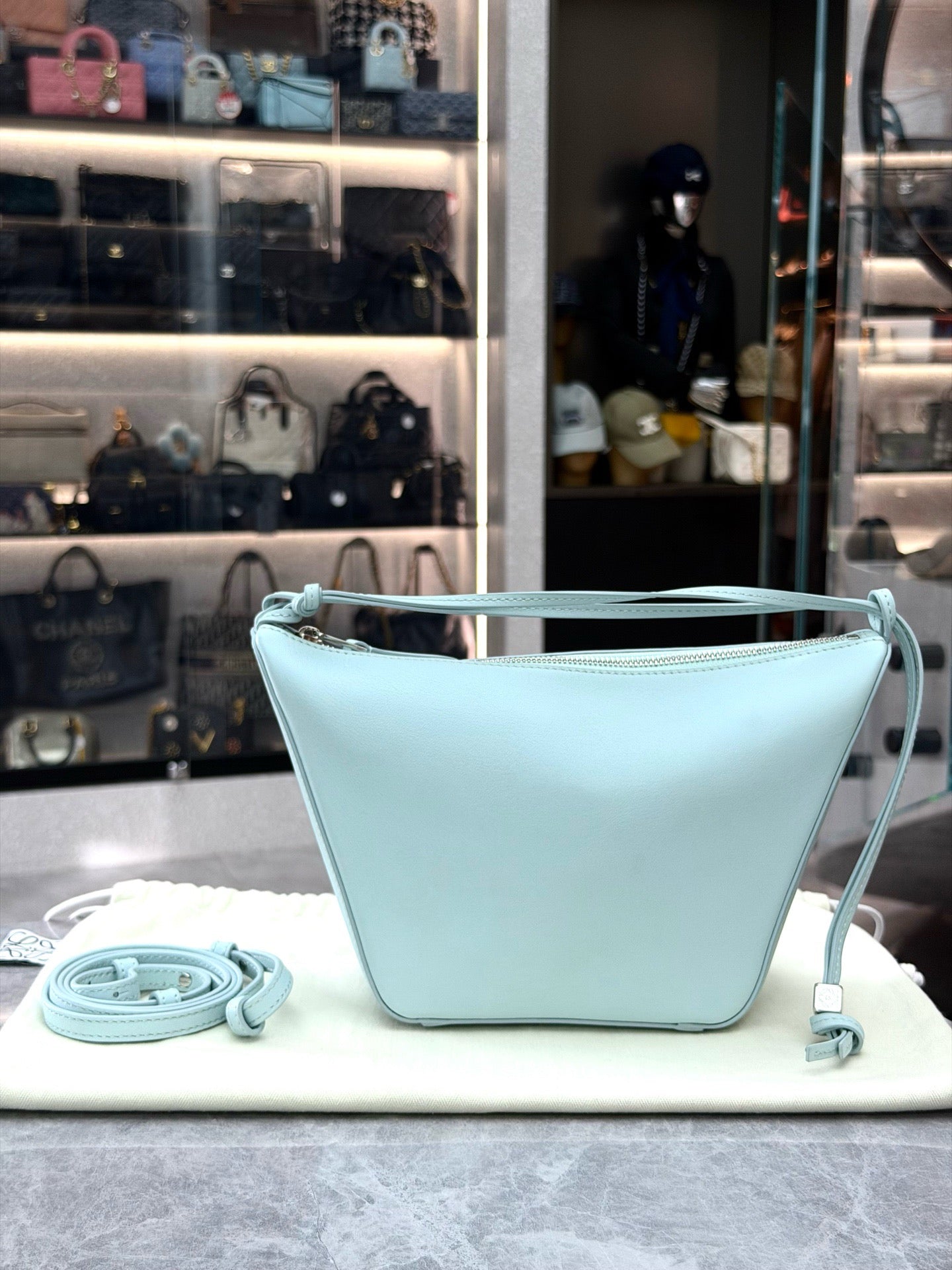 Loewe Mini Hammock Hobo bag features a distinct curved shape crafted from light blue calfskin leather