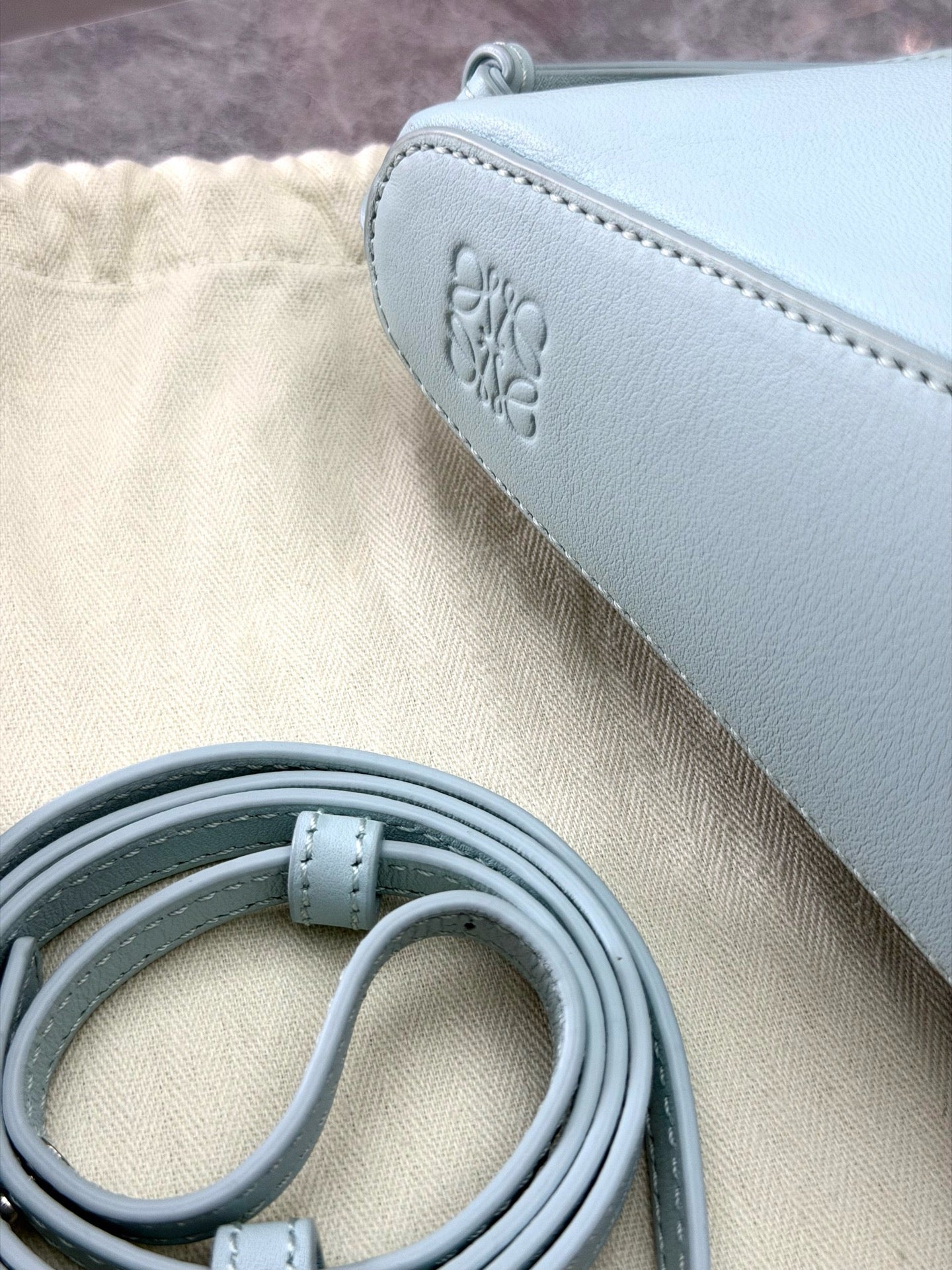 Loewe Mini Hammock Hobo bag features a distinct curved shape crafted from light blue calfskin leather
