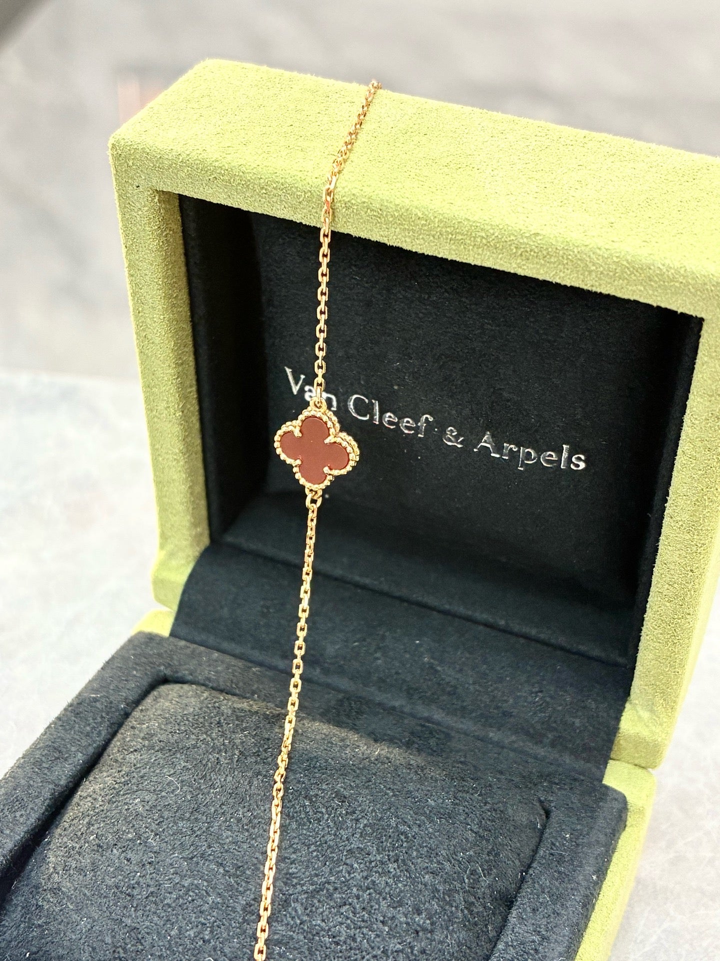 Van Cleef & Arpels Sweet Alhambra bracelet features a single clover motif crafted from red carnelian and 18K rose gold