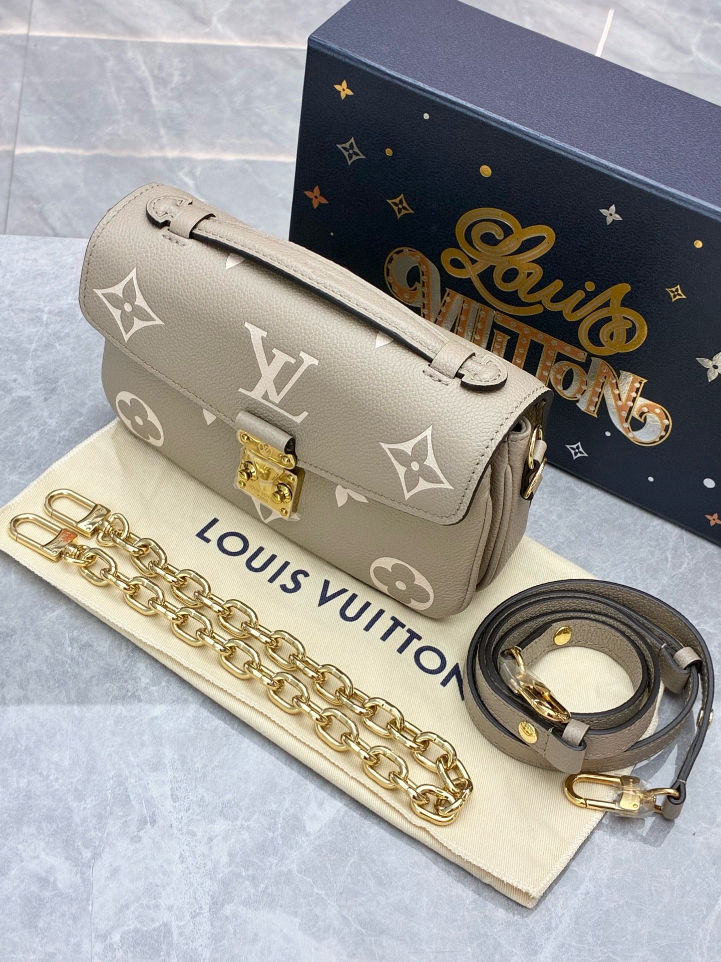 LOUIS VUITTON Pochette Métis East West – Elephant Grey Monogram Empreinte, Gold Hardware, Brand New