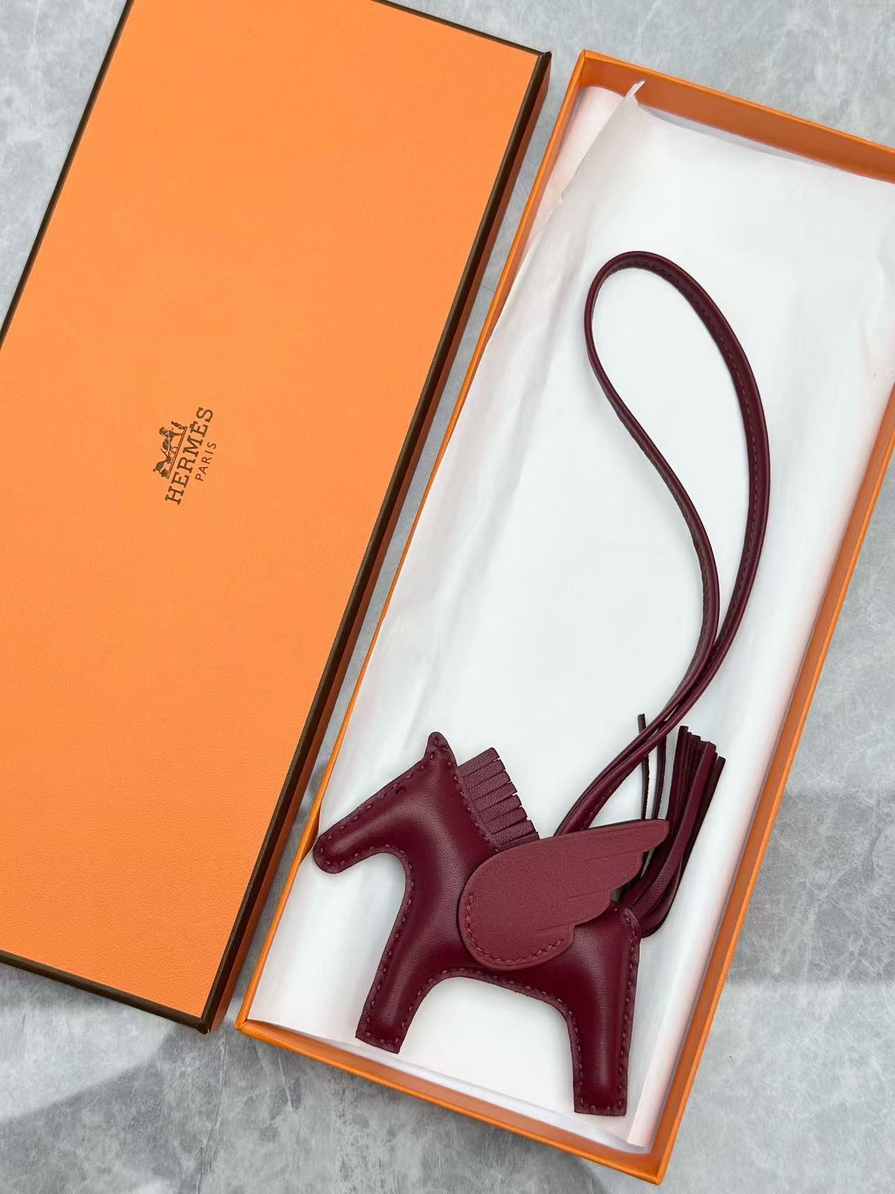 Hermès Rodeo Pegase PM bag charm in a burgundy color