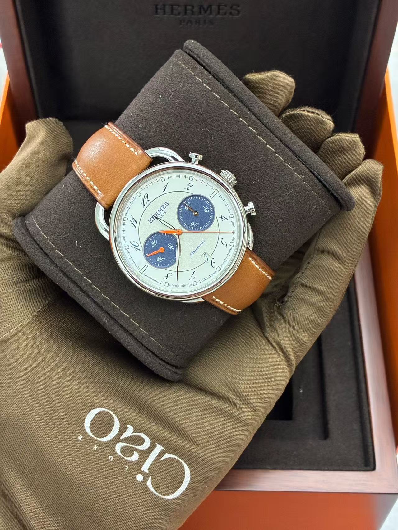 Hermès Arceau Chronograph 42mm watch featuring a white silvered dial, blue counters, and a brown leather strap