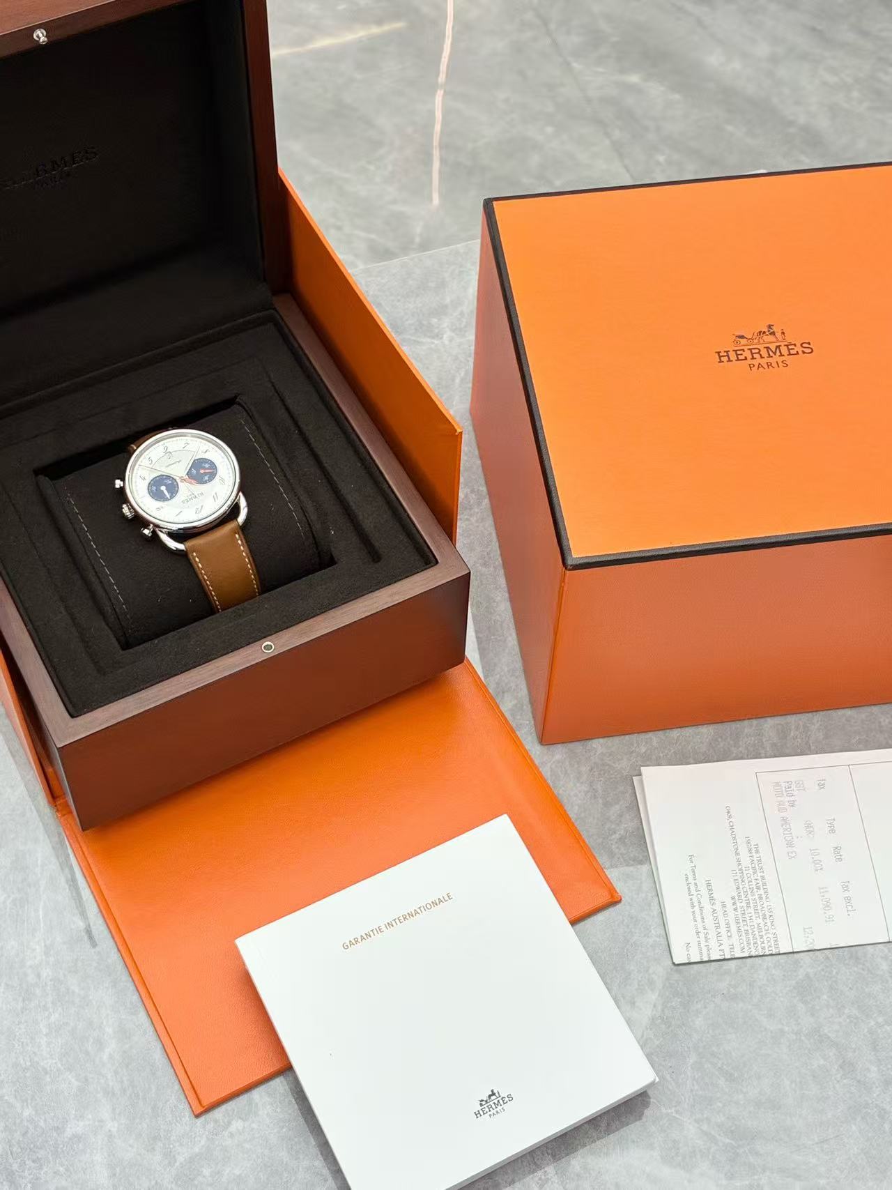 Hermès Arceau Chronograph 42mm watch featuring a white silvered dial, blue counters, and a brown leather strap