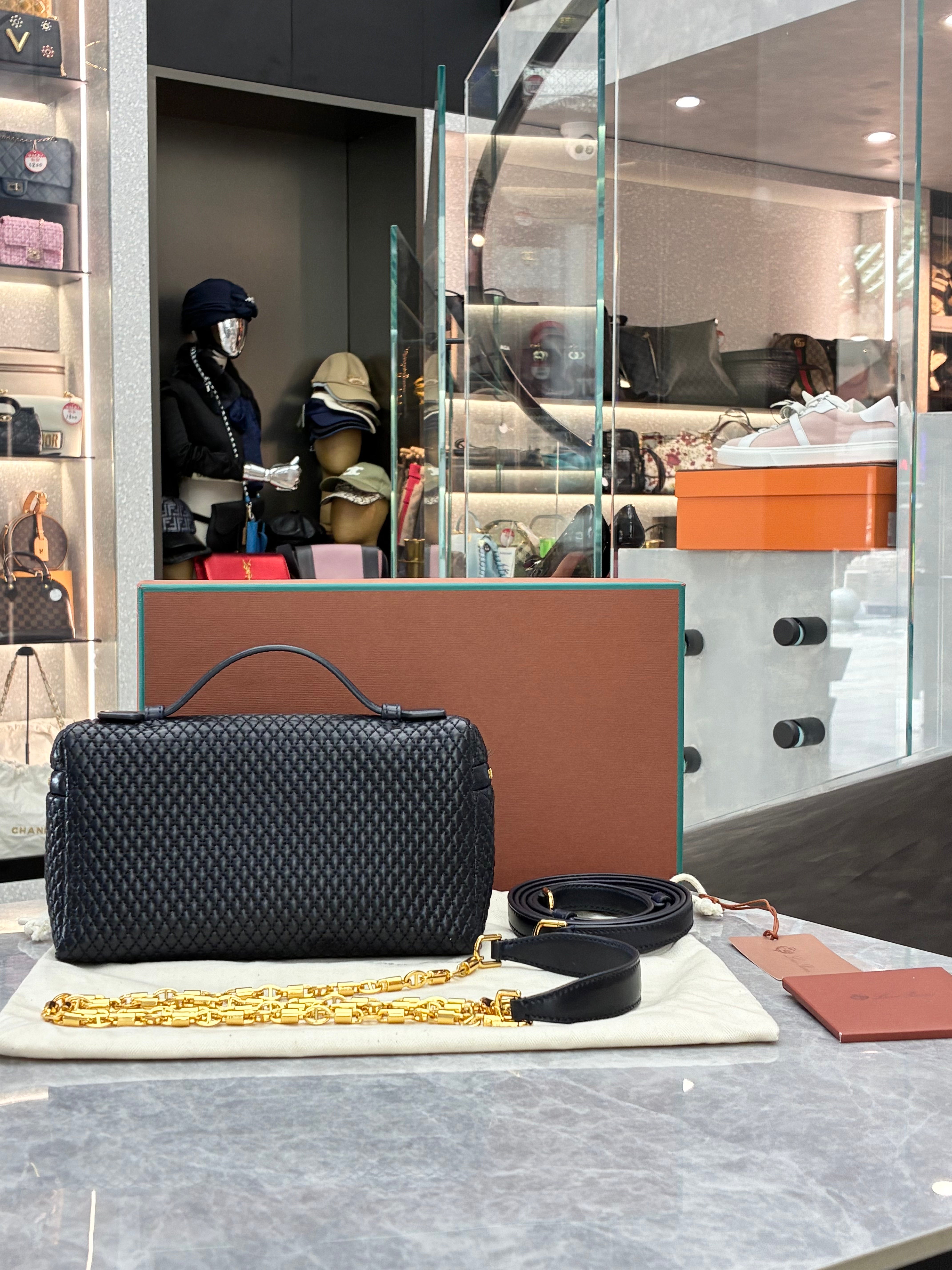 Loro Piana Extra Pocket L19 quilted leather pouch, featuring a structured silhouette with top handle and detachable strap