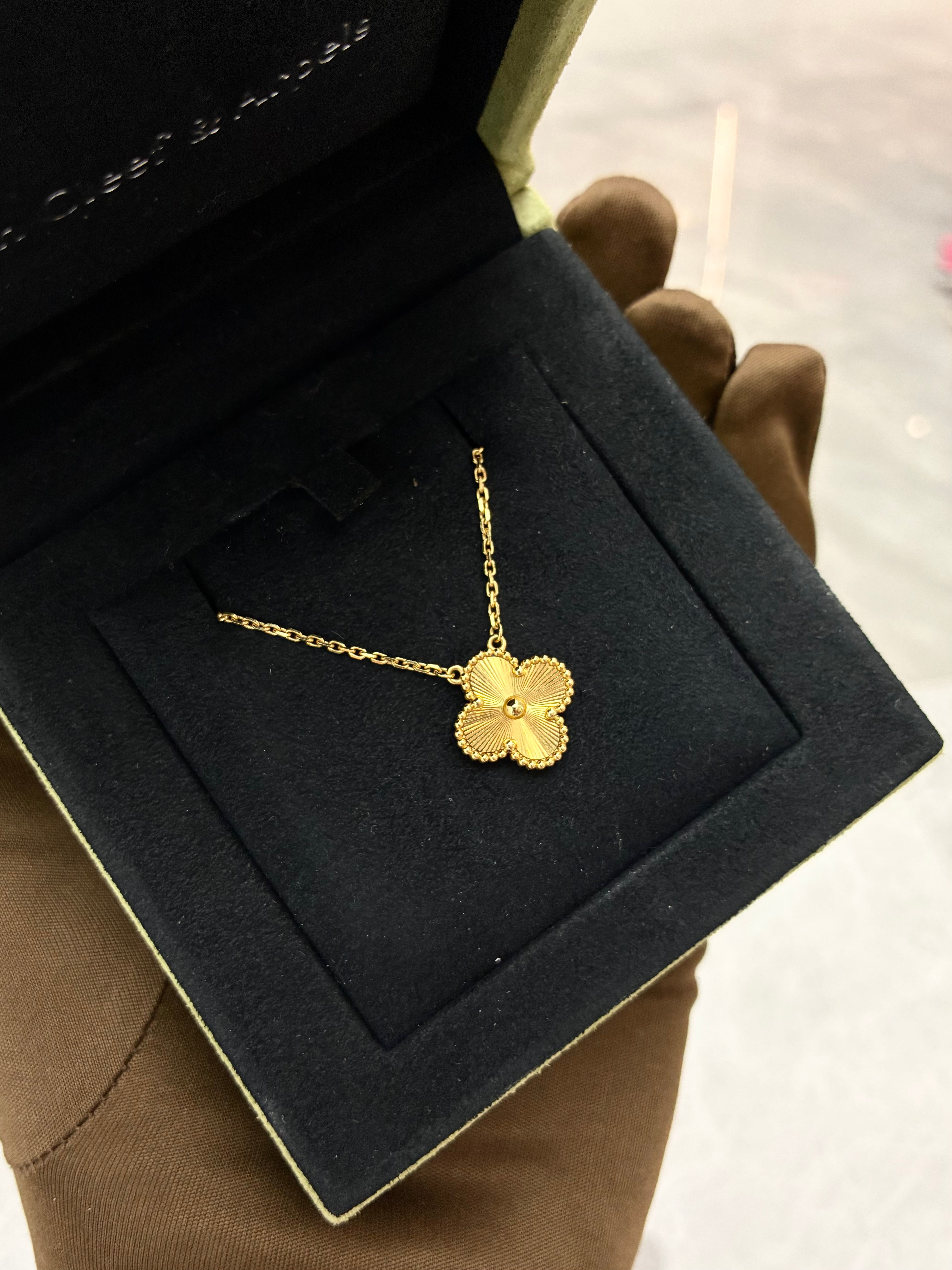 Van Cleef & Arpels Vintage Alhambra pendant necklace features a clover motif crafted in 18K yellow gold with a guilloché pattern