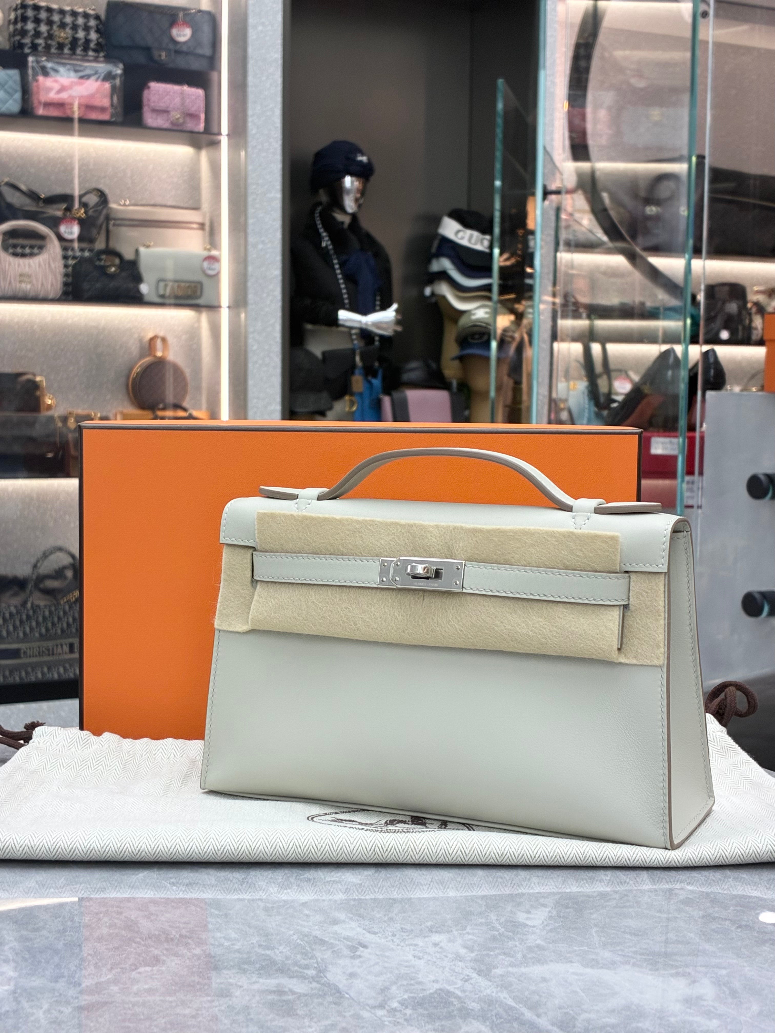 Hermès Kelly Pochette, often crafted in leathers like Swift in colors Gris Perle, paired with palladium hardware
