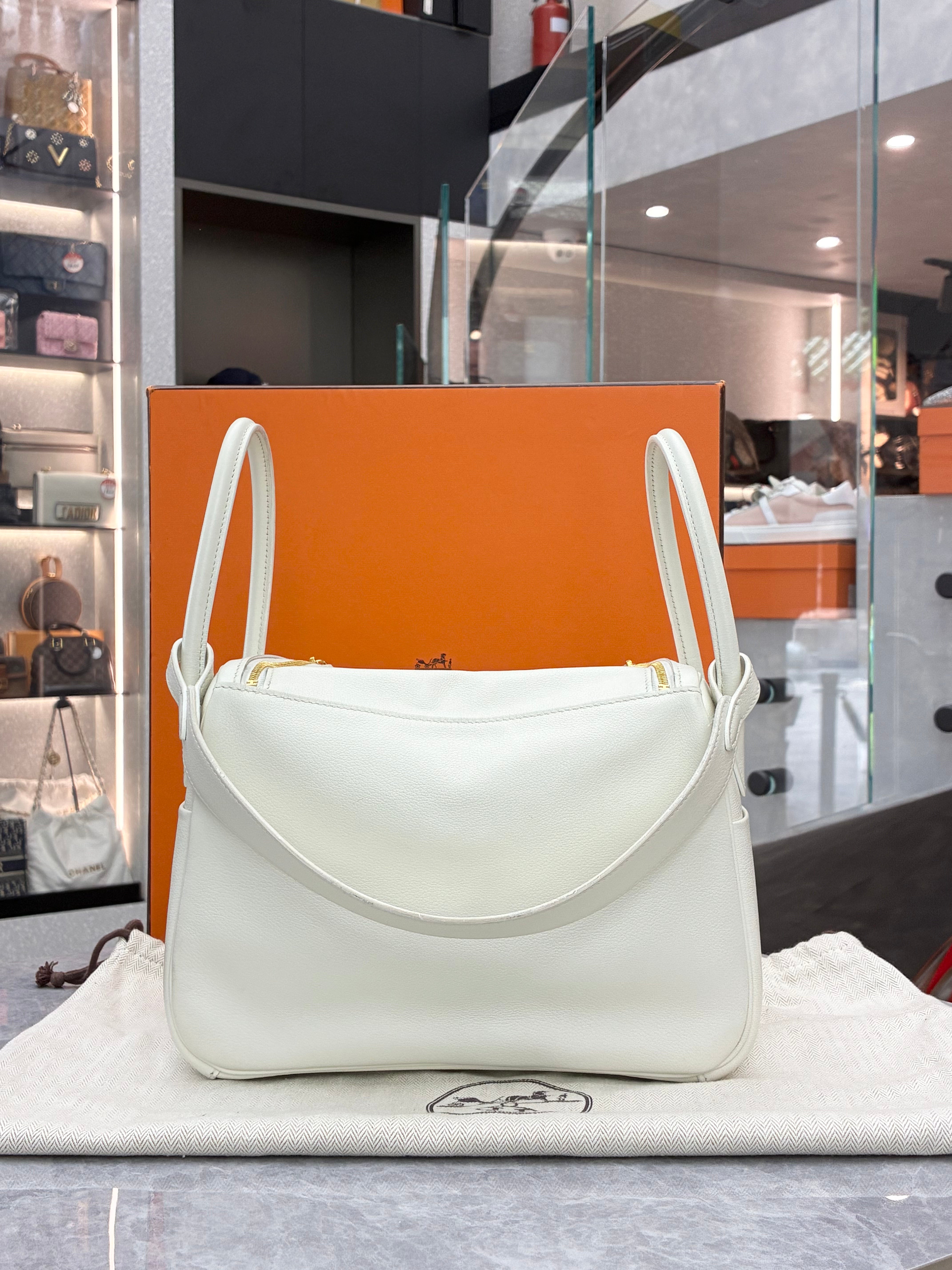 Hermès white Lindy 26 bag featuring gold-tone hardware.