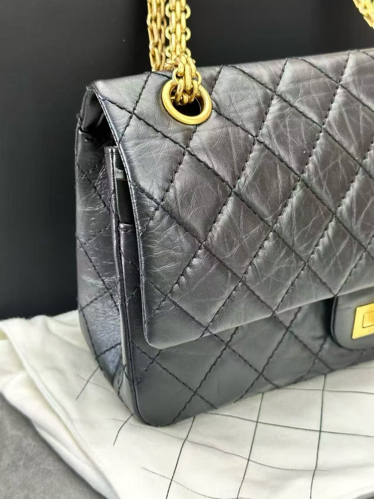 Chanel 2.55 Reissue flap handbag, crafted from black aged calfskin leather and featuring gold-tone hardware