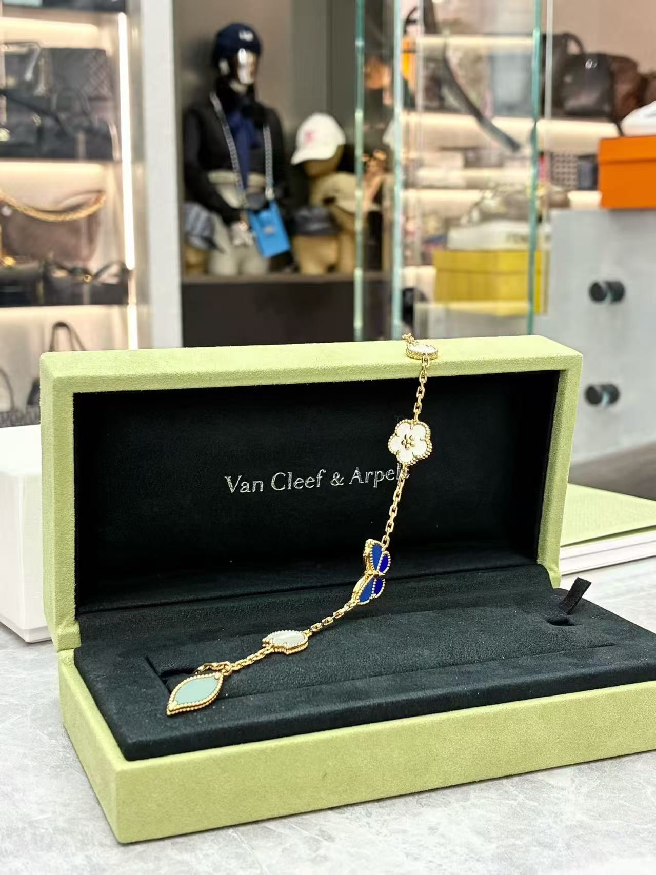 Van Cleef & Arpels Lucky Spring Butterfly bracelet in 18K yellow gold, featuring motifs made from white mother-of-pearl, onyx, lapis lazuli, and agate