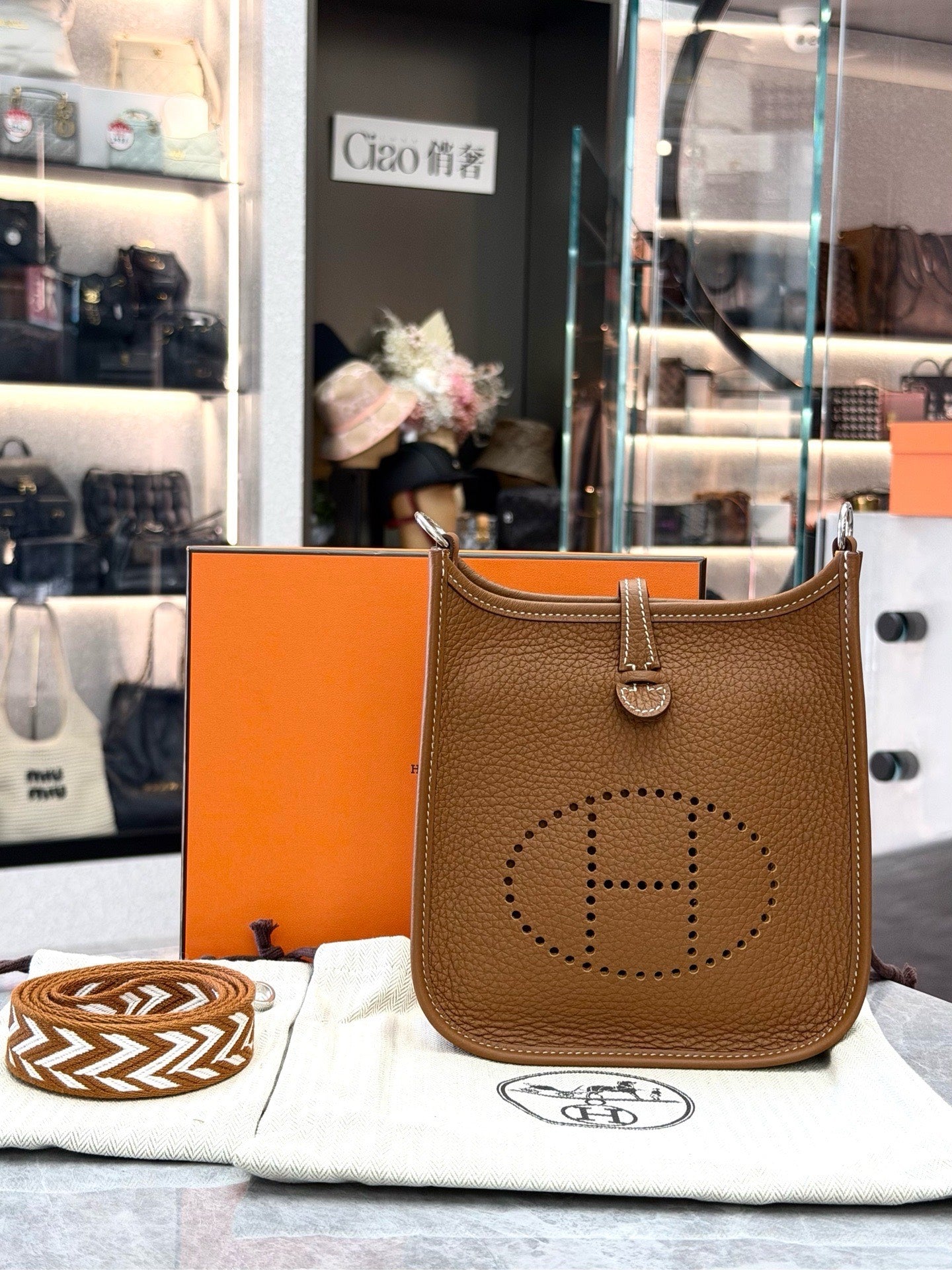 HERMÈS Mini Evelyne – Gold Taurillon Clemence, Palladium Hardware, Geometric Woven Strap, U Stamp, Brand New